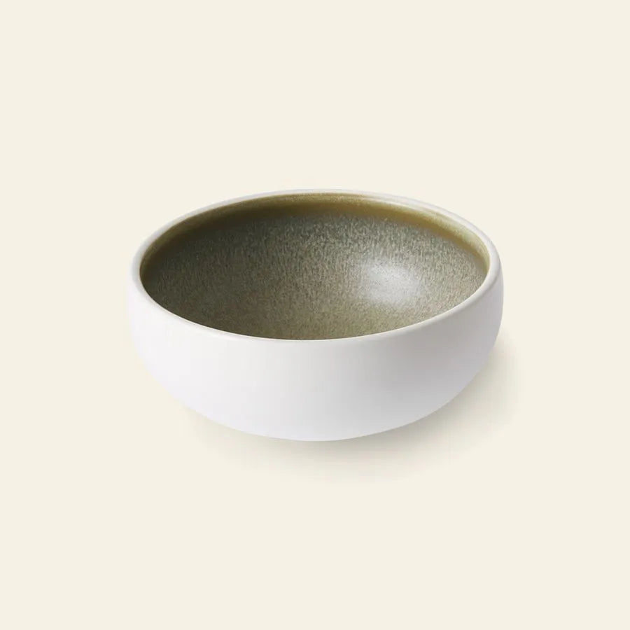 The HKliving Chef Ceramics: Bowl by HKliving features a white exterior and textured olive-green interior, hand finished for a unique touch—an elegant tableware essential displayed on a plain light background.