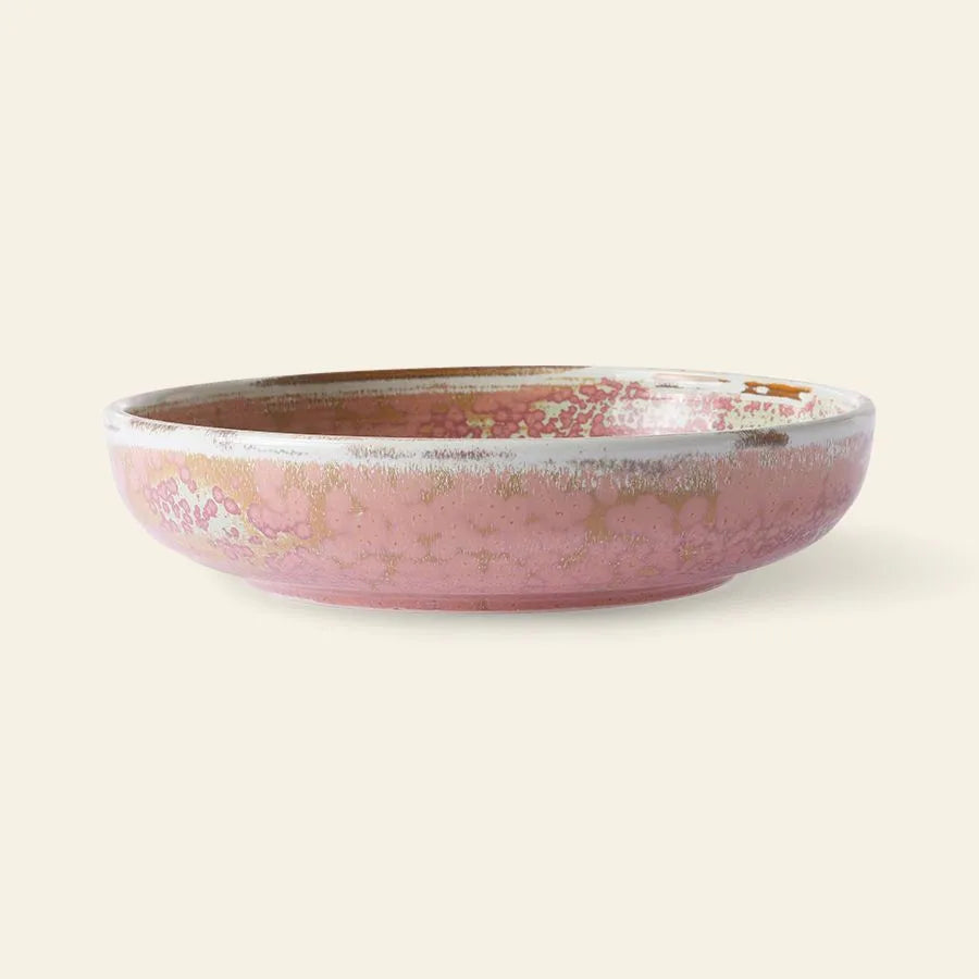 The HKliving Chef Ceramics: Deep Plate M is a round ceramic bowl with a pink reactive glaze and mottled patterns, offering artisanal charm against a simple, light background.