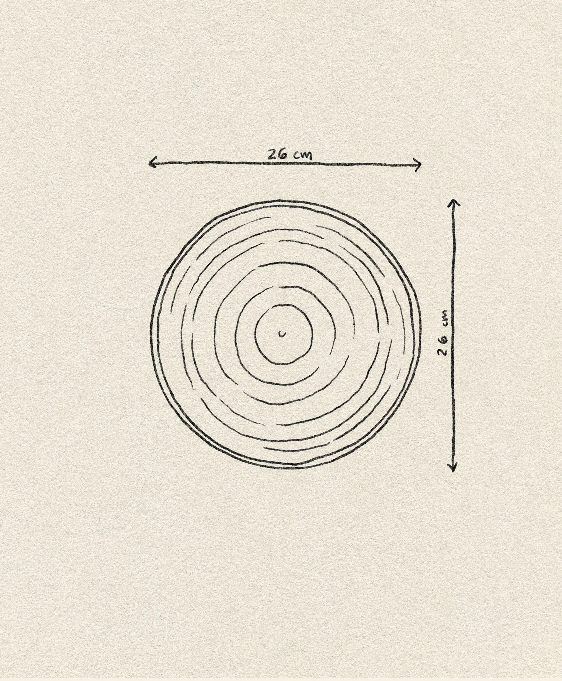 A hand-drawn circle with concentric rings, resembling tree rings, reflects the design of the HKliving Chef Ceramics: Dinner Plate by HKliving. Two arrows labeled 26 cm indicate its diameter and height on a beige textured background.