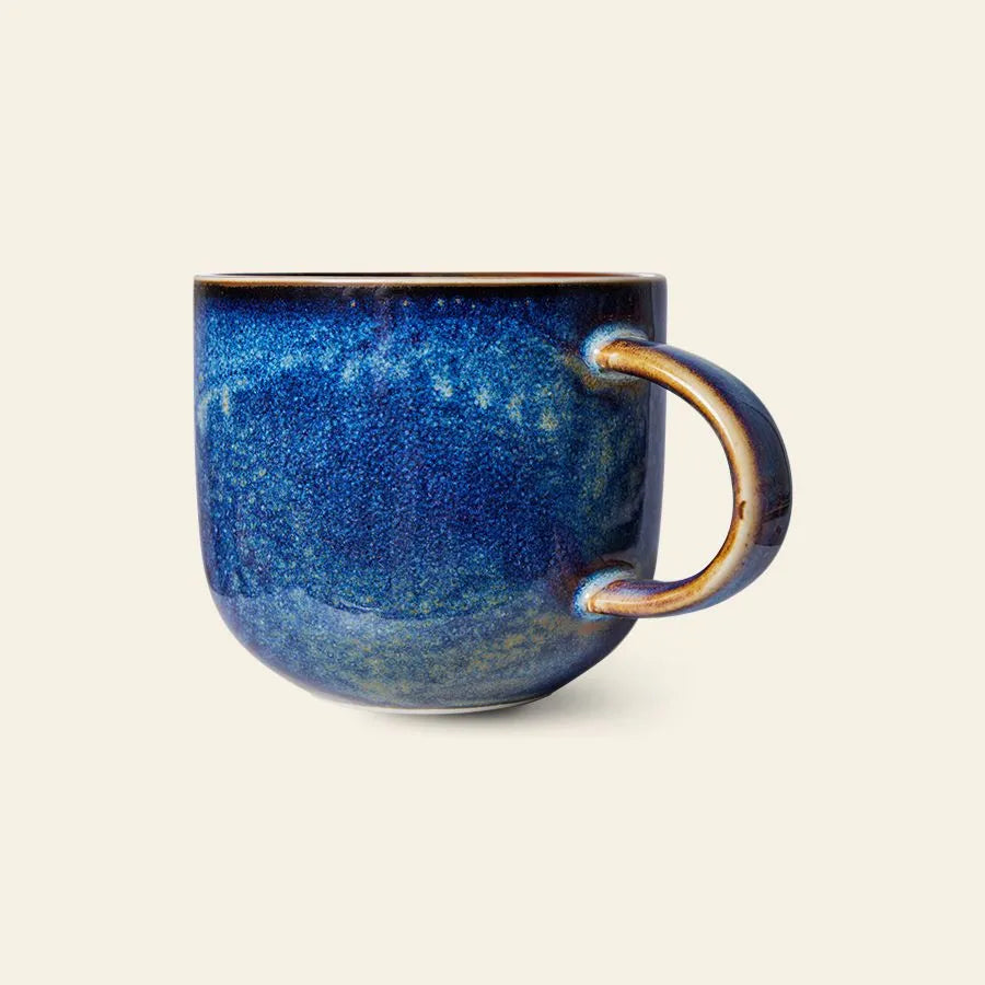 The HKliving Chef Ceramics: Mug features a rounded shape and glossy, textured blue glaze with varied tones, adding artisanal charm to your tableware. Shown against a plain, light background.