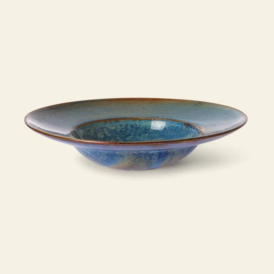 The HKliving Chef Ceramics: Pasta Plate is a shallow, round ceramic plate with a wide rim, featuring a glossy blue glaze and brown-edged detail—a stylish tableware essential from HKliving.