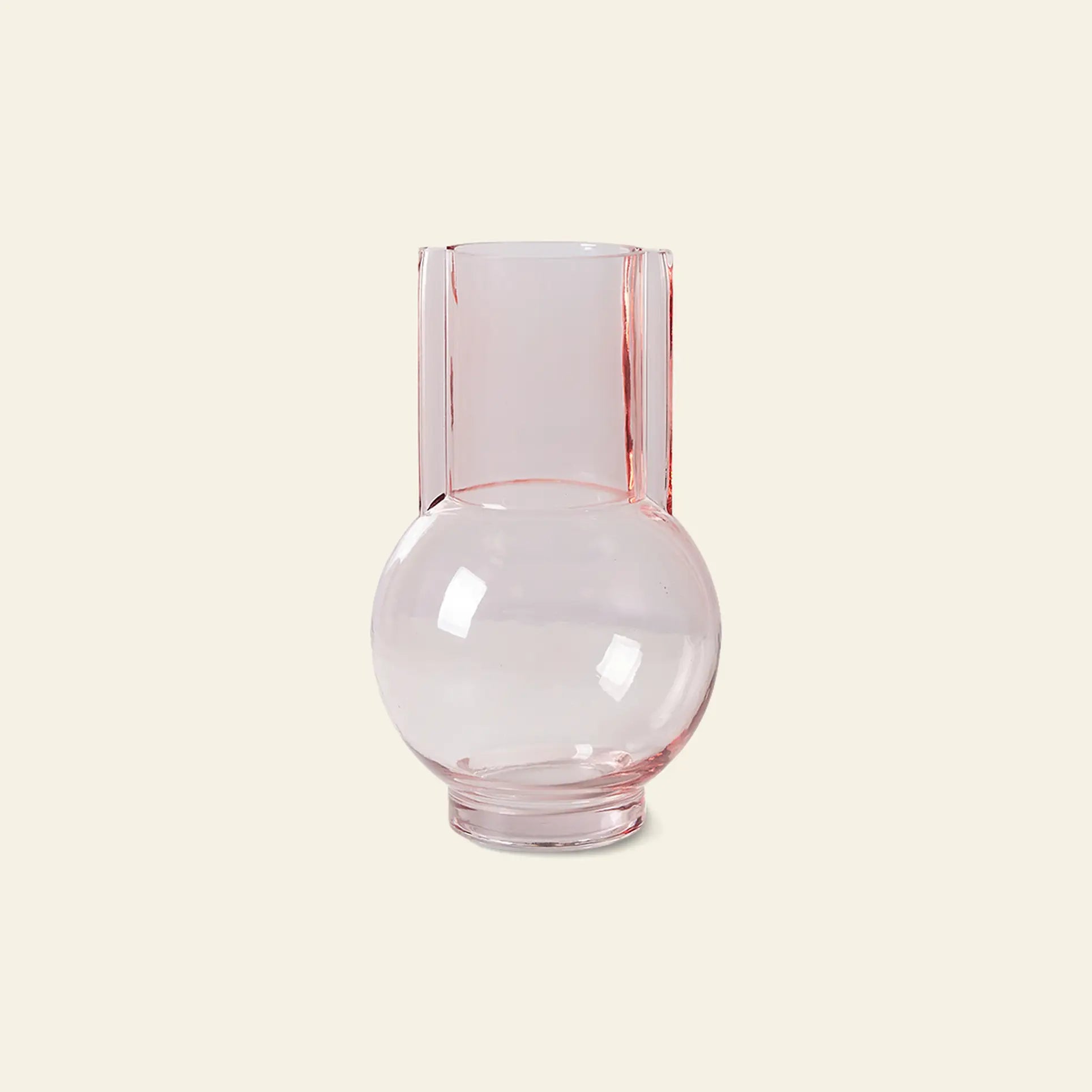 The HKliving Glass Vase Sundae Pink features a clear, light pink design with a round base and tall cylindrical neck, adding charm and brightness to any space. Shown here against a plain, off-white background.