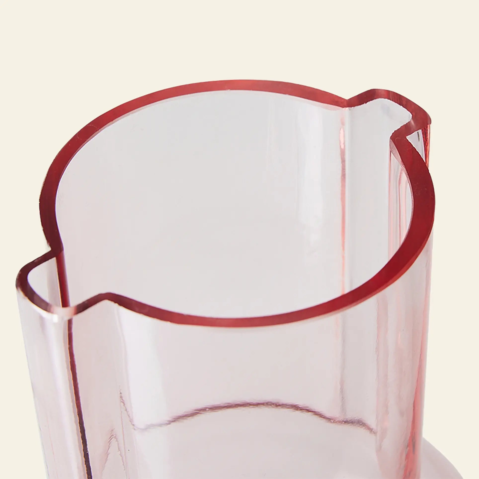A close-up of the HKliving Glass Vase Sundae Pink, featuring a translucent pink finish and wavy rim, highlights the charm of HKliving vases against a light beige background.