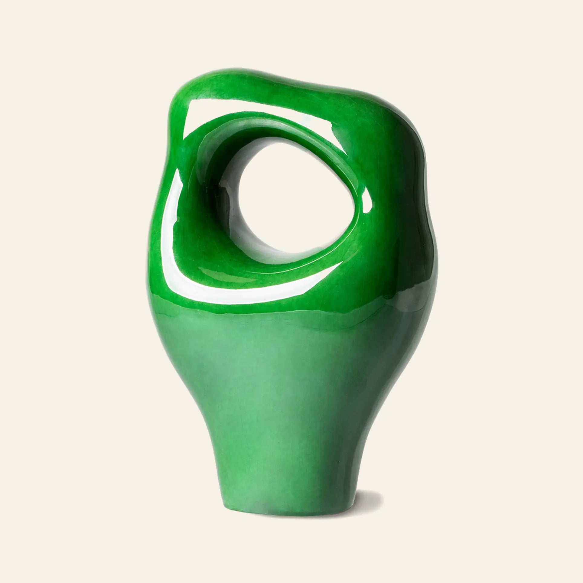 The HKliving HK Objects: Ceramic Sculpture by HKliving features a glossy green finish, abstract organic shape, and a large oval hole, making it a striking accent for any modern space with a light background.