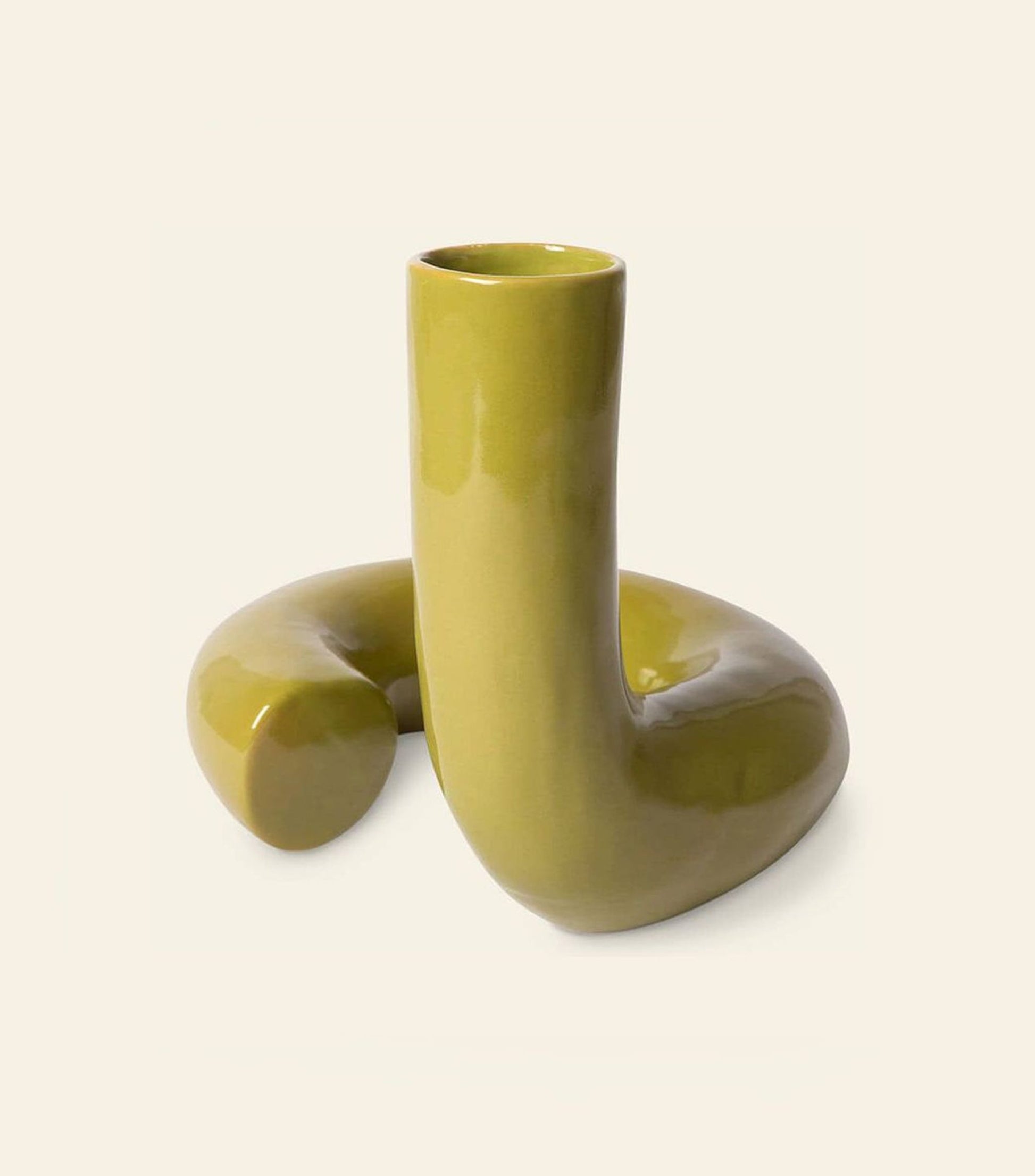 The HKliving HK Objects: Ceramic Twisted Vase by HKliving features a glossy green finish and a unique, curved looping design. One end stands upright while the other curves downward, set against a plain beige background.