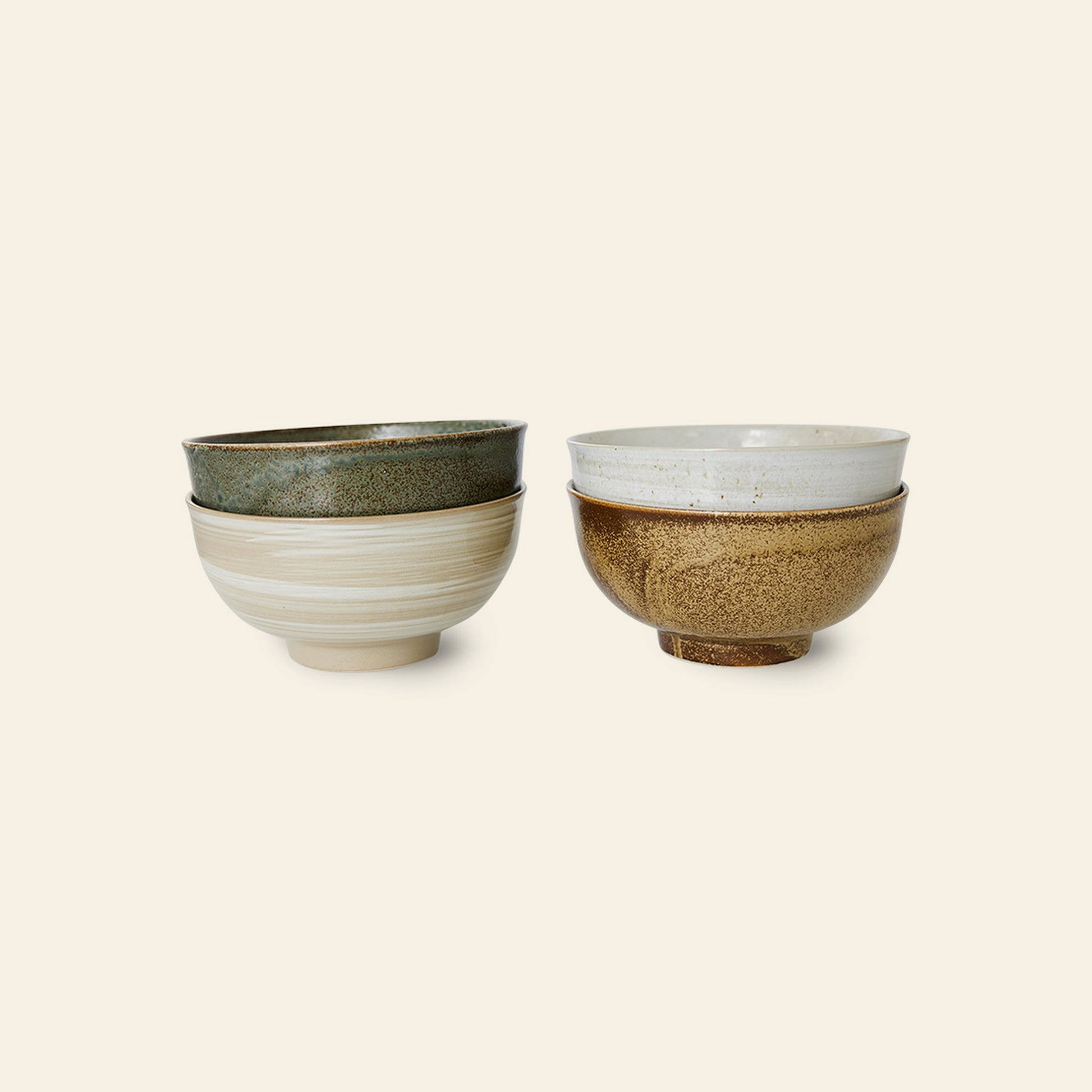 A stack of three HKliving Kyoto Ceramics Japanese Noodle Bowls in green, beige, and cream is placed next to a brown and cream bowl from the HKliving Kyoto Ceramics set of 4, all arranged on a light beige background.