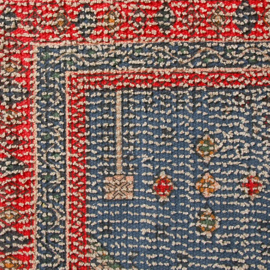 The HKliving Printed Bathmat Overtufted by HKliving features a blue field with small geometric patterns and a red border. Its silicone layer provides anti-slip safety and texture—ideal for adding vibrant style to your bathroom decor.