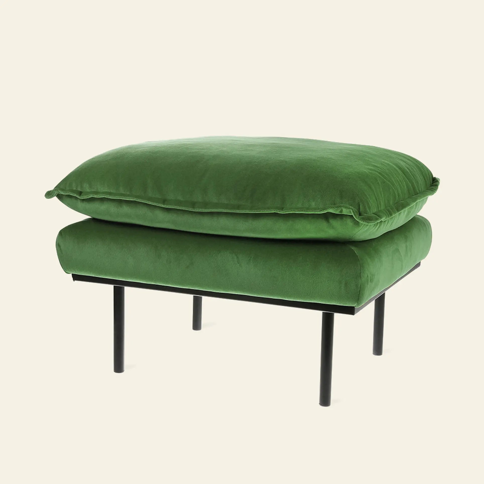 The HKliving Retro Sofa, Hocker by HKliving features a plush green velvet cushion and slim black metal legs, offering modern comfort and style to any living area against a light backdrop.