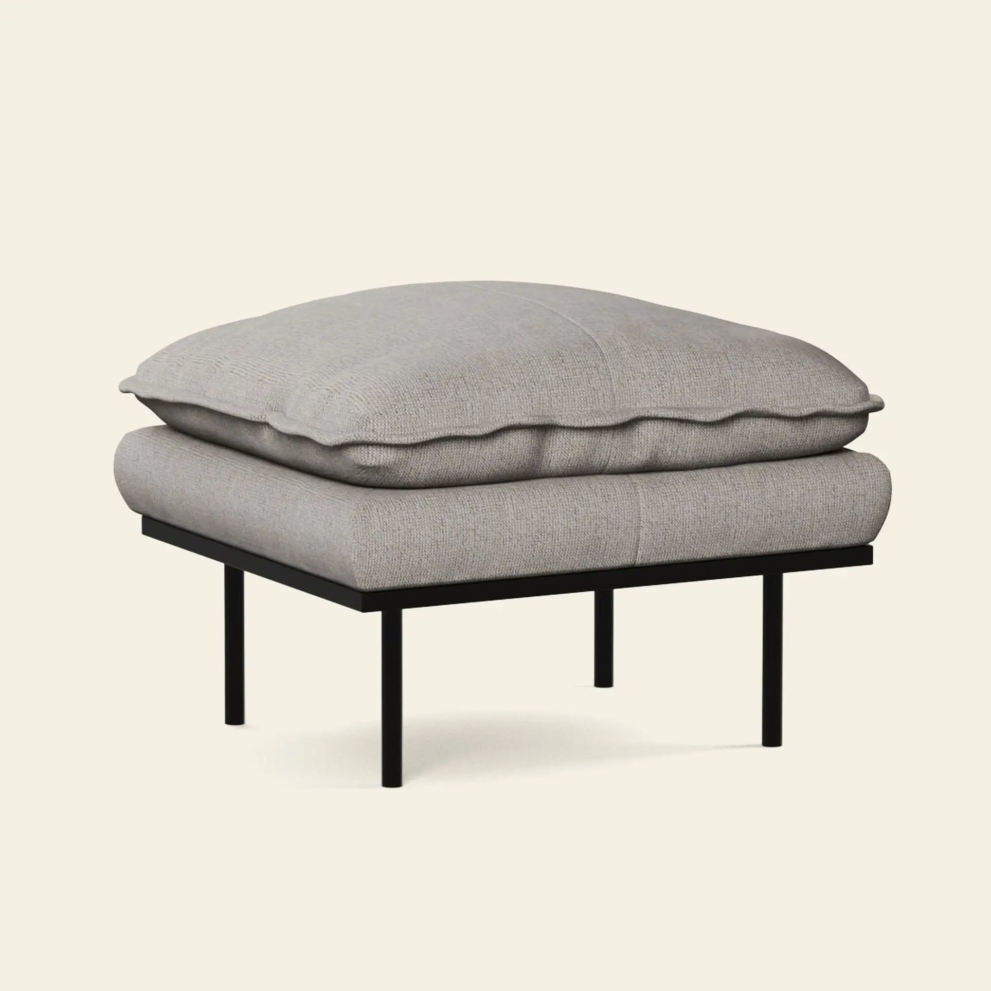 The HKliving Retro Sofa, Hocker by HKliving features a thick light gray cushion and black metal legs, offering modern comfort to your living space, shown here against a plain beige background.