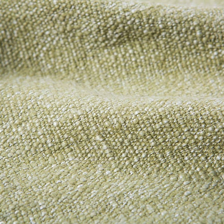 Close-up of the HKliving Soft Woven Throw With Black Tufted Lines by HKliving, showing its textured green fabric with a cosy, slightly bumpy surface and raised pattern highlighted by gentle folds and shadows.