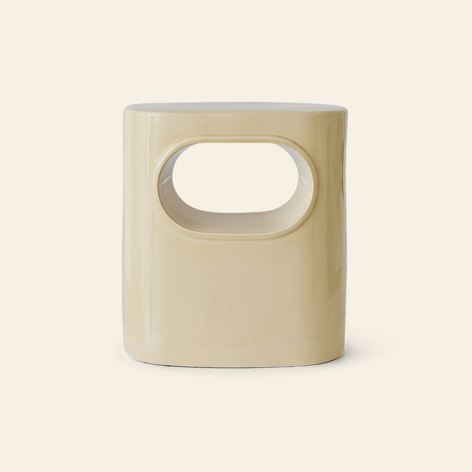 The HKliving Space Side Table by HKliving features a beige ceramic finish with a central oval cutout, offering modern style and versatile use as a side table, storage, or extra seating—ideal against a light background.