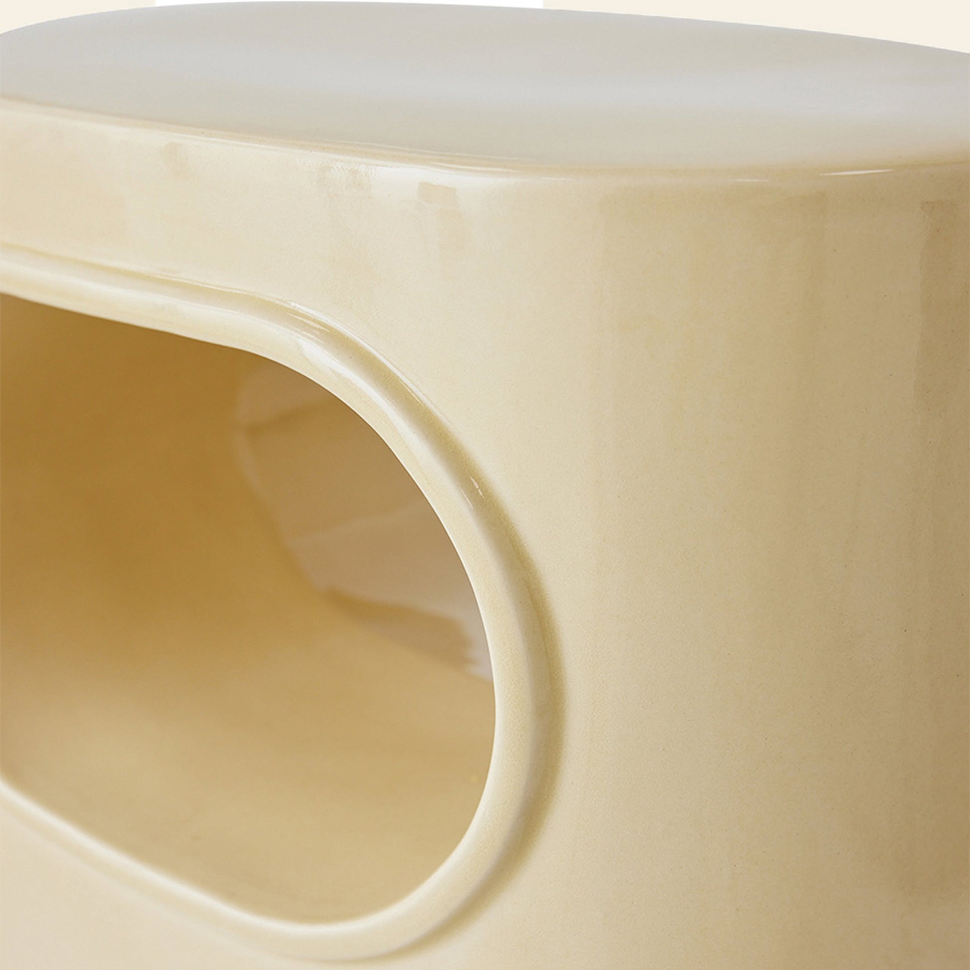 Close-up of the HKliving Space Side Table by HKliving—a smooth, glossy, light beige piece with a rounded rectangular form and large oval opening, showcasing modern multifunctional design.