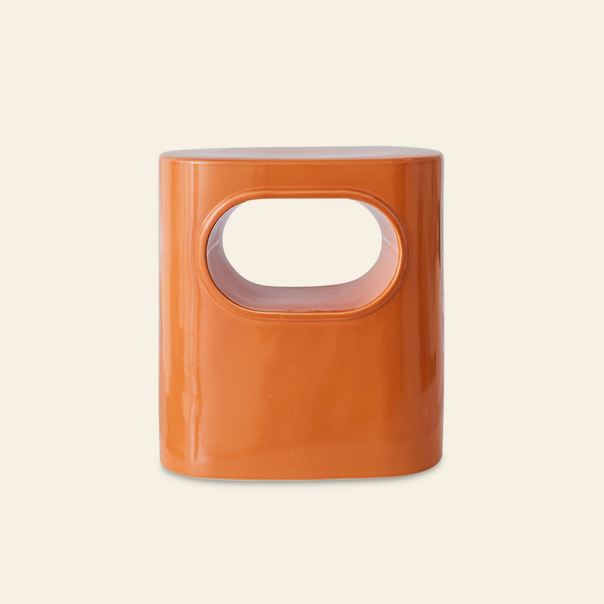 The HKliving Space Side Table by HKliving is a glossy orange rectangular ceramic stool with an oval cutout in the center, featuring modern design and convenient storage, displayed against a plain light beige background.