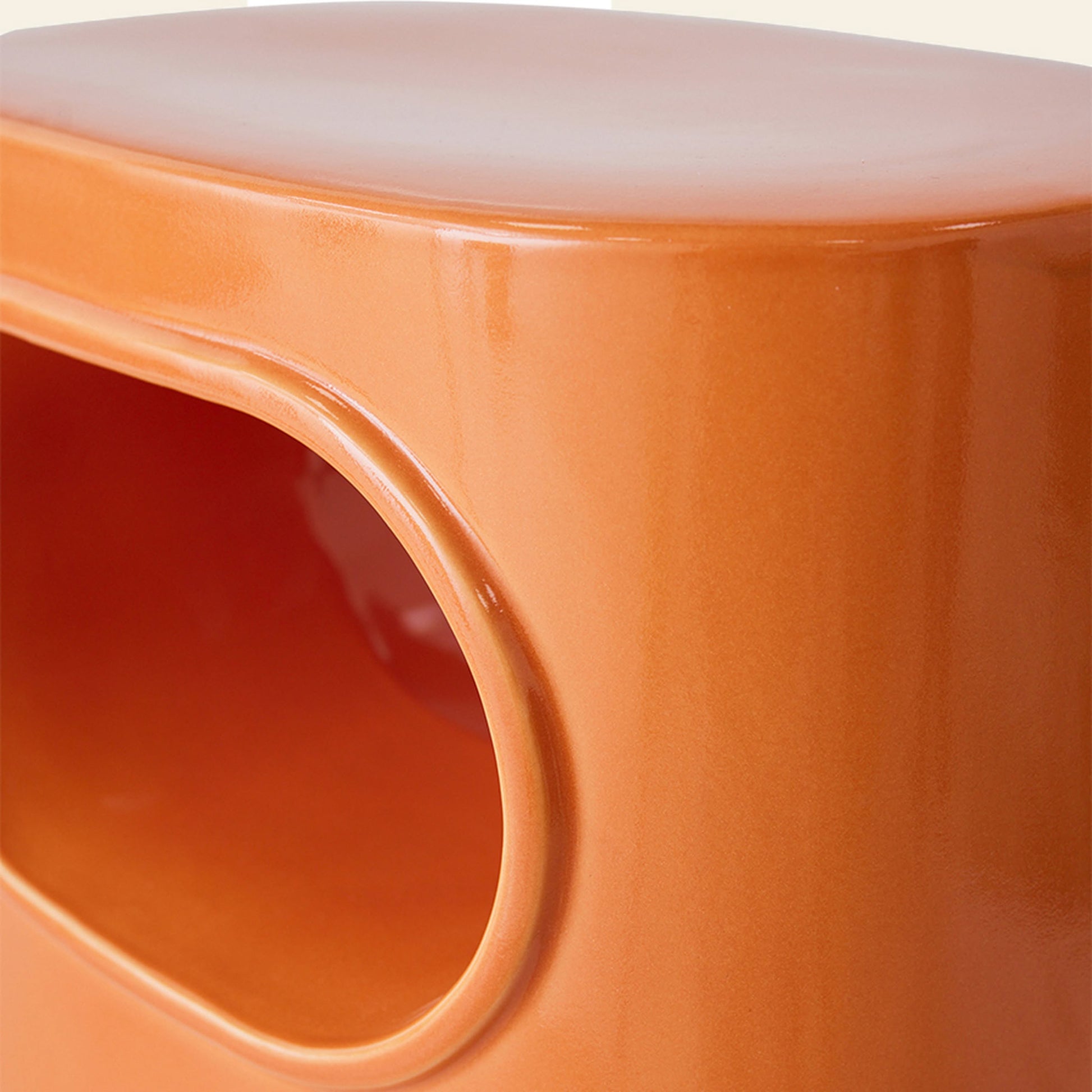 The HKliving Space Side Table by HKliving features a glossy orange ceramic finish, a rounded rectangular shape with an oval cutout on the side—ideal as a modern, multifunctional side table with built-in storage.