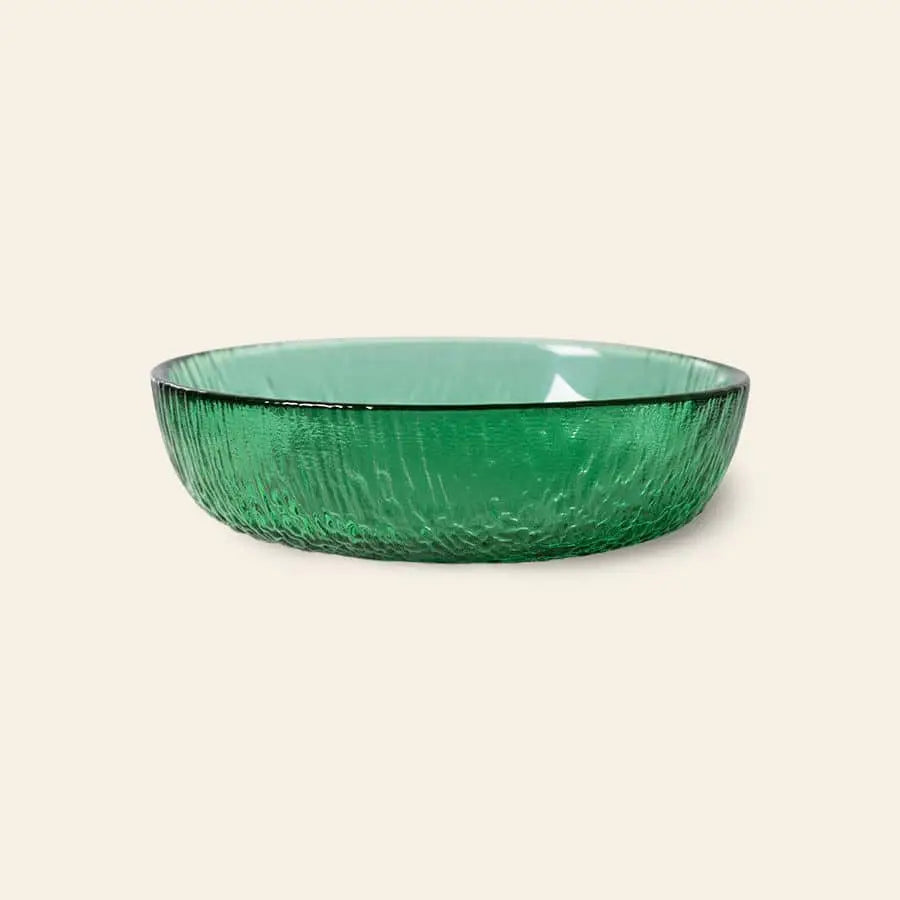 The HKliving The Emeralds: Glass Dessert Bowl, with its modern round design and textured green glass, brings contemporary elegance. Displayed on a light beige background, the bowl adds charm to any table setting.