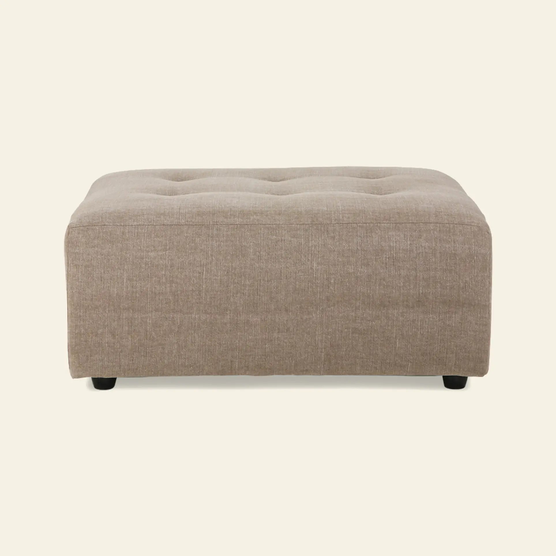 A rectangular, beige HKliving Vint Couch Hocker ottoman with subtle tufted top detailing, designed to complement the HKliving Vint sofa and provide customizable seating, shown against a plain light background.