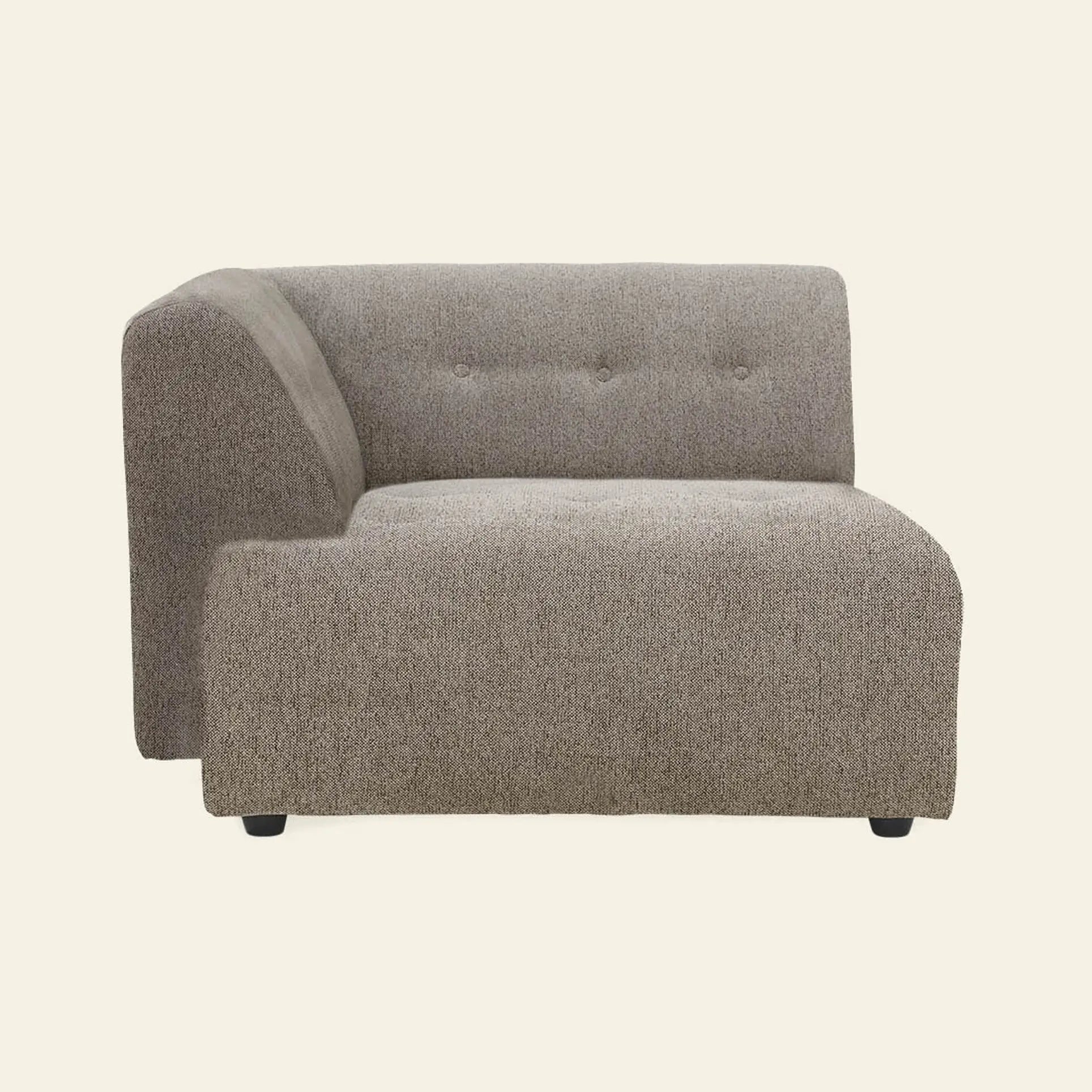 The HKliving Vint Couch, Left Divan by HKliving features a modern light brown design with a low backrest, tufted buttons, and a wide seat. Part of the customizable Vint collection. Shown against an off-white background.