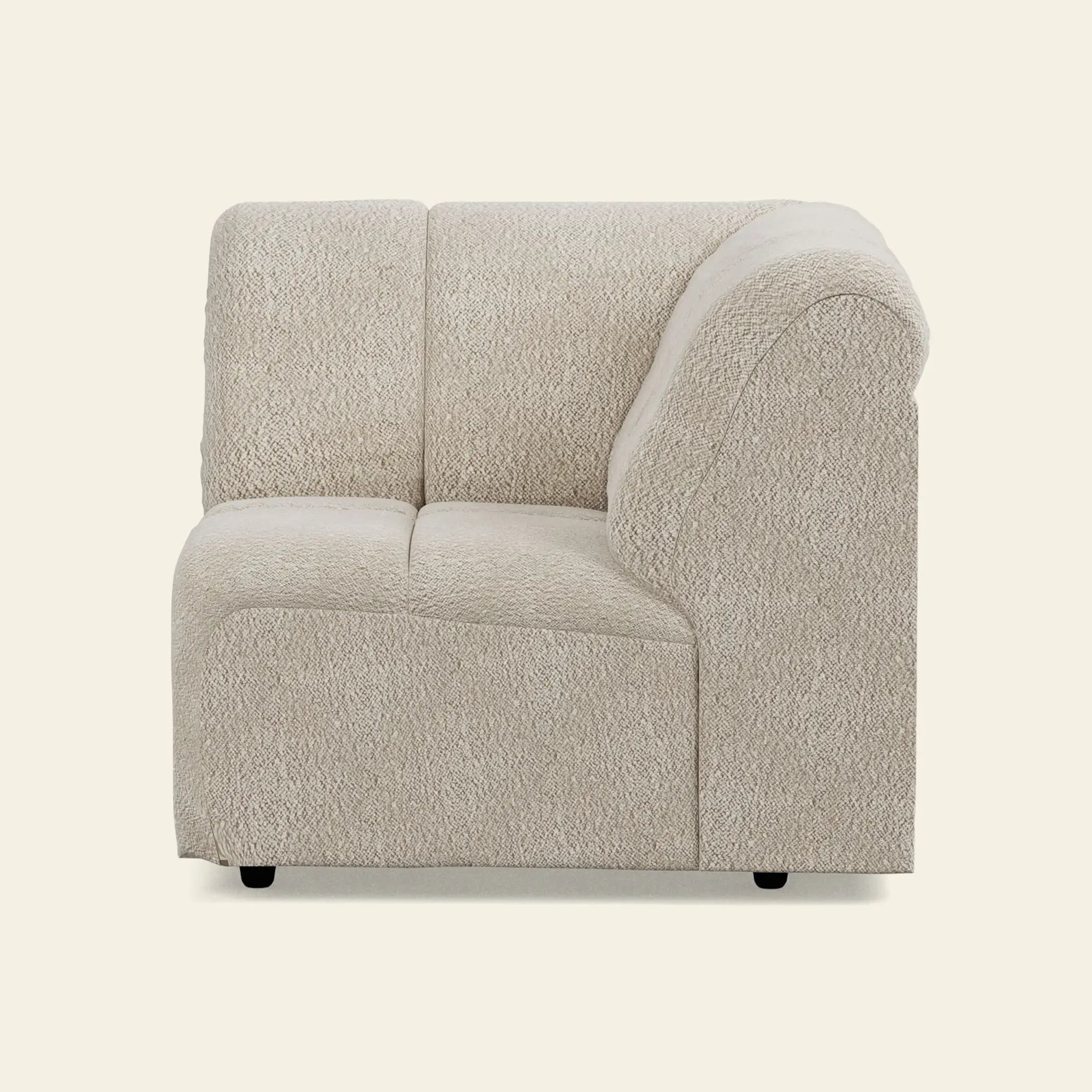 The HKliving Wave Couch, Corner by HKliving is a modern light beige textured fabric sofa with rounded edges and a low backrest, shown here customizable and set against a plain off-white background.