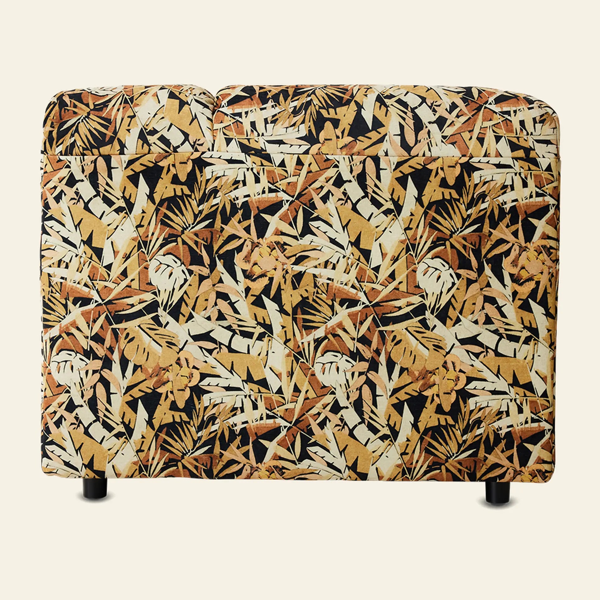The HKliving Wave Couch, Corner by HKliving is a small, contemporary sofa with a bold tropical leaf fabric in brown, yellow, black, and cream. Shown from the back, it features two sections and short black legs.