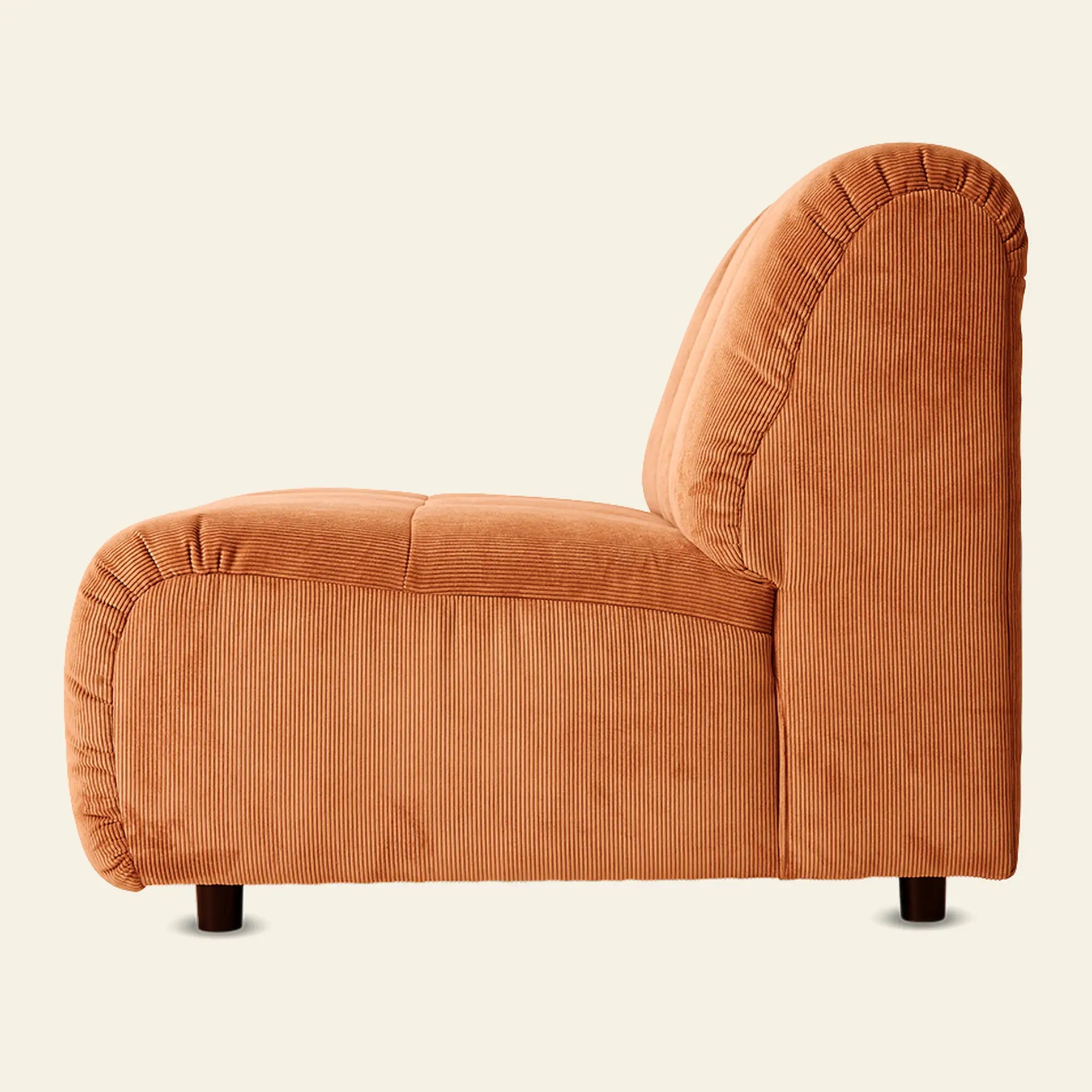 Side view of the HKliving Wave Couch, Middle by HKliving, a modern armless accent chair inspired by 1970s design, featuring thick padding and textured orange corduroy upholstery on short dark wooden legs against a light background.
