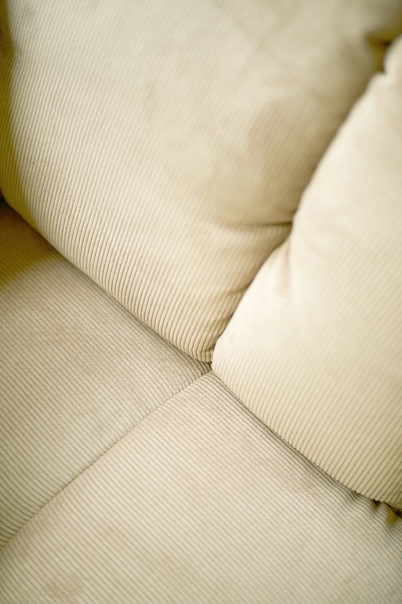 Close-up of the HKliving Wave Couch, Middle by HKliving, showing its beige corduroy-textured fabric with vertical stripes, two seat and two back cushions, plus plush 1970s-inspired design.