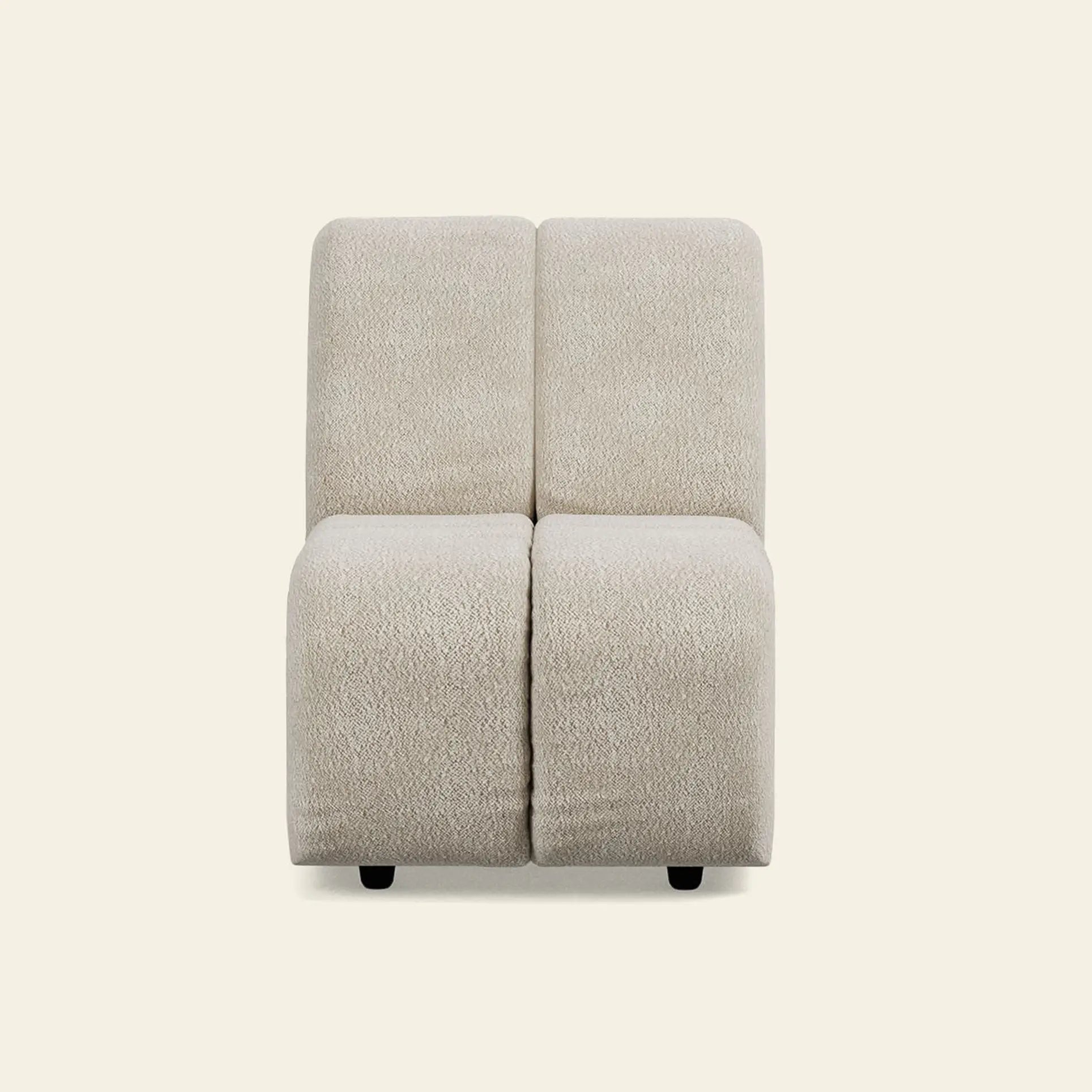 The HKliving Wave Couch, Middle Small by HKliving is a modern armless beige fabric chair with two segmented cushions and short black legs, inspired by 1970s design and shown against a plain light background.