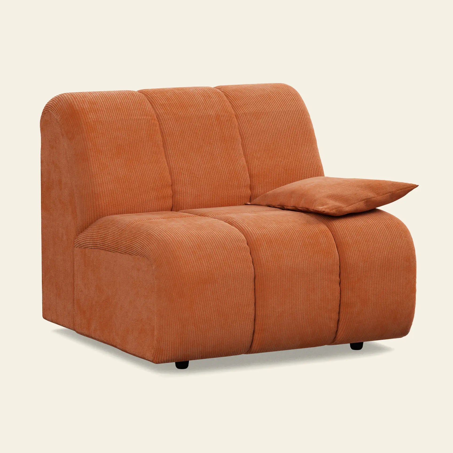 The HKliving Wave Couch, Right Low Arm by HKliving is a modern armless lounge chair in rust-colored corduroy with rounded edges and a matching rectangular pillow, perfect for adding warmth to any living room.