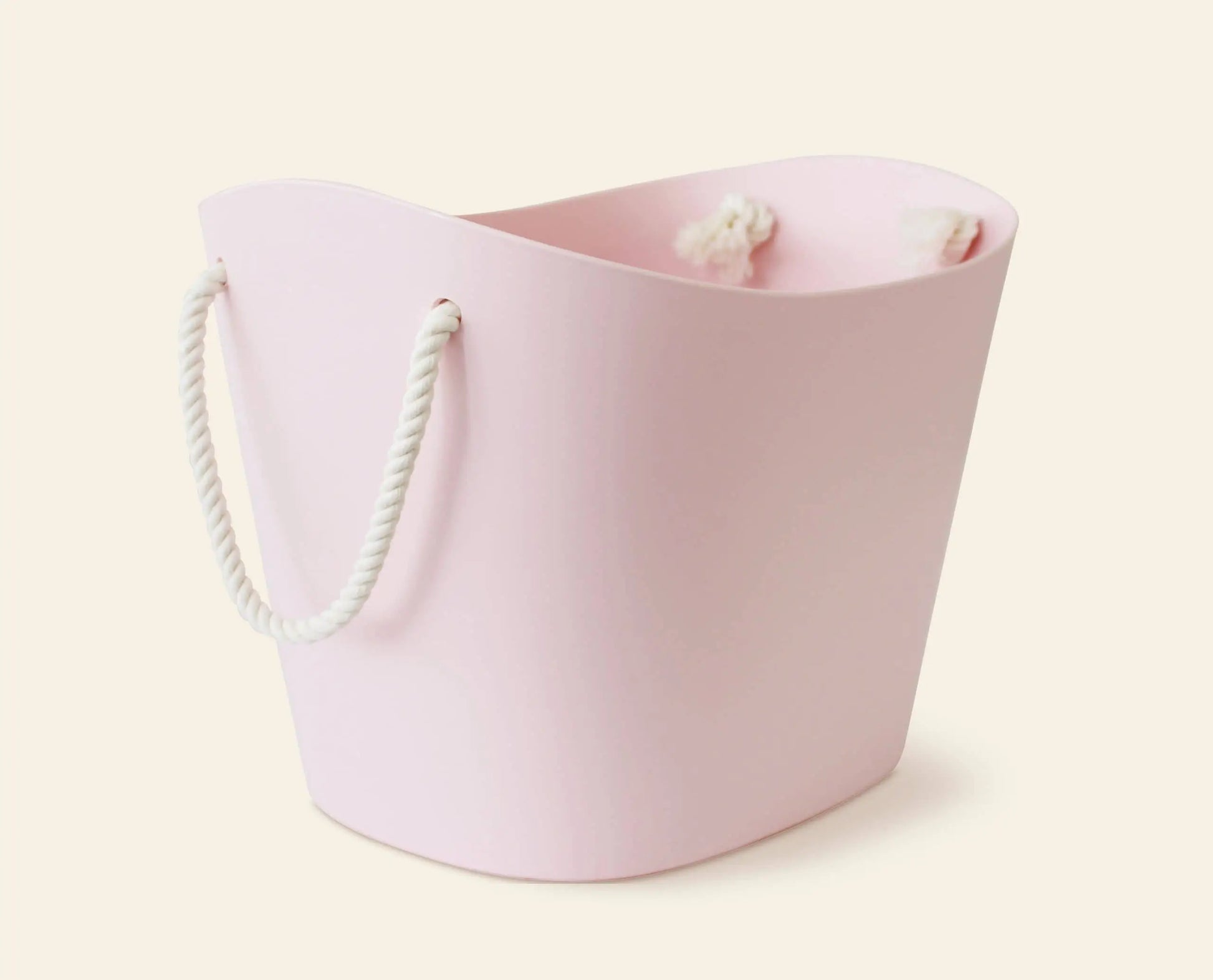 A pale pink, oval Hachiman Balcolore Storage Basket M with white rope handles, set on a cream background. This minimalist Japanese Hachiman design suits versatile storage, with white fabric seen inside.