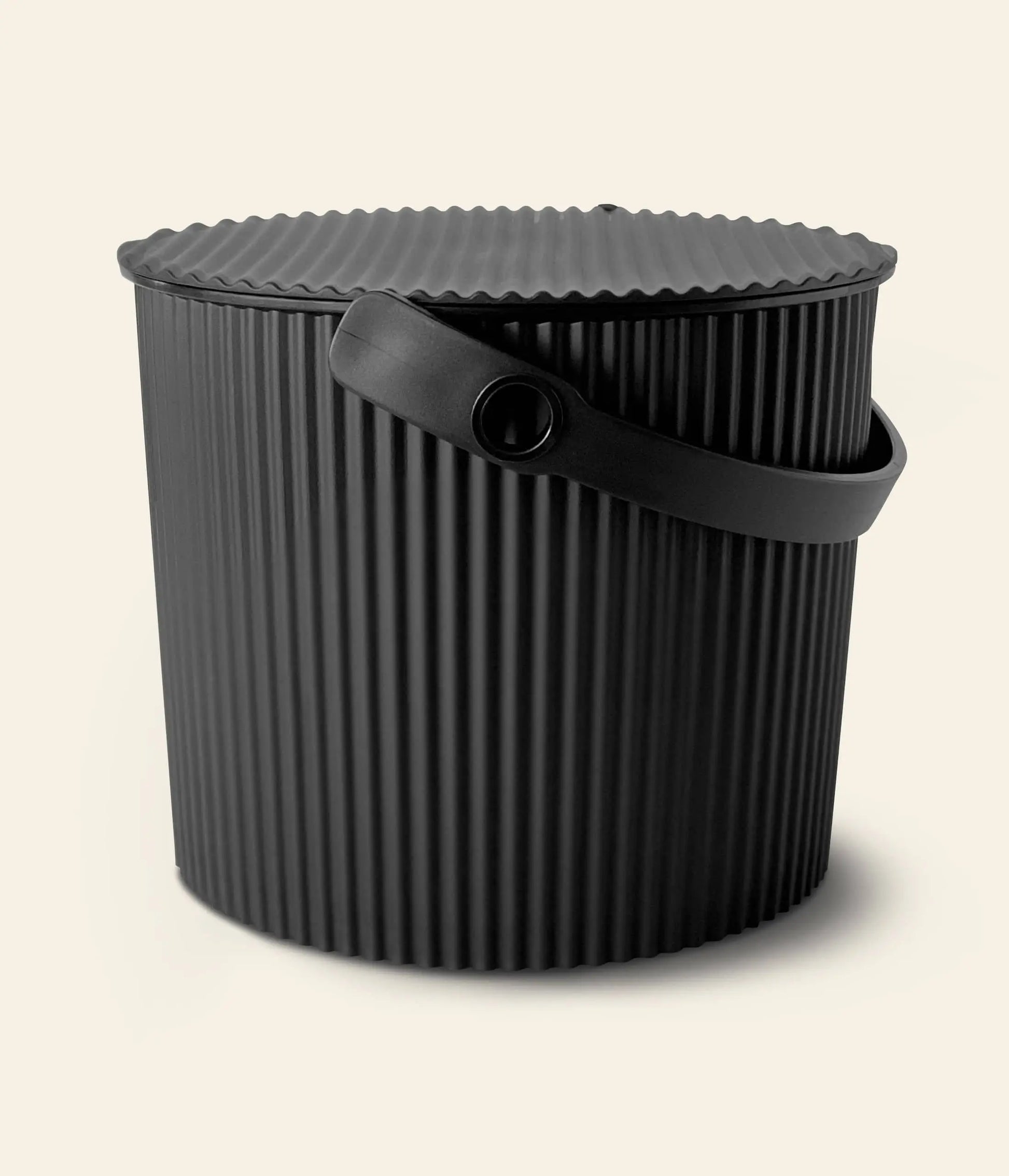 A black Hachiman Omnioutil Storage Bucket S with ribbed sides, a ridged lid, and sturdy handle for indoor or outdoor use, shown against a plain light background.