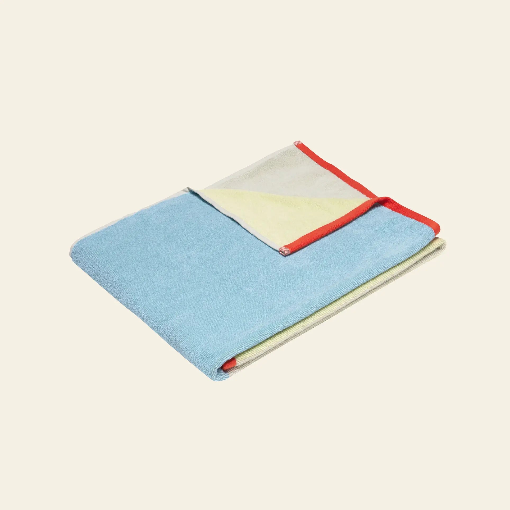 The Hübsch Block Towel Large by Hübsch, crafted from STANDARD 100 By Oeko-Tex cotton, features folded panels of light blue, yellow, and cream with a red border along one edge, displayed on a plain light background.