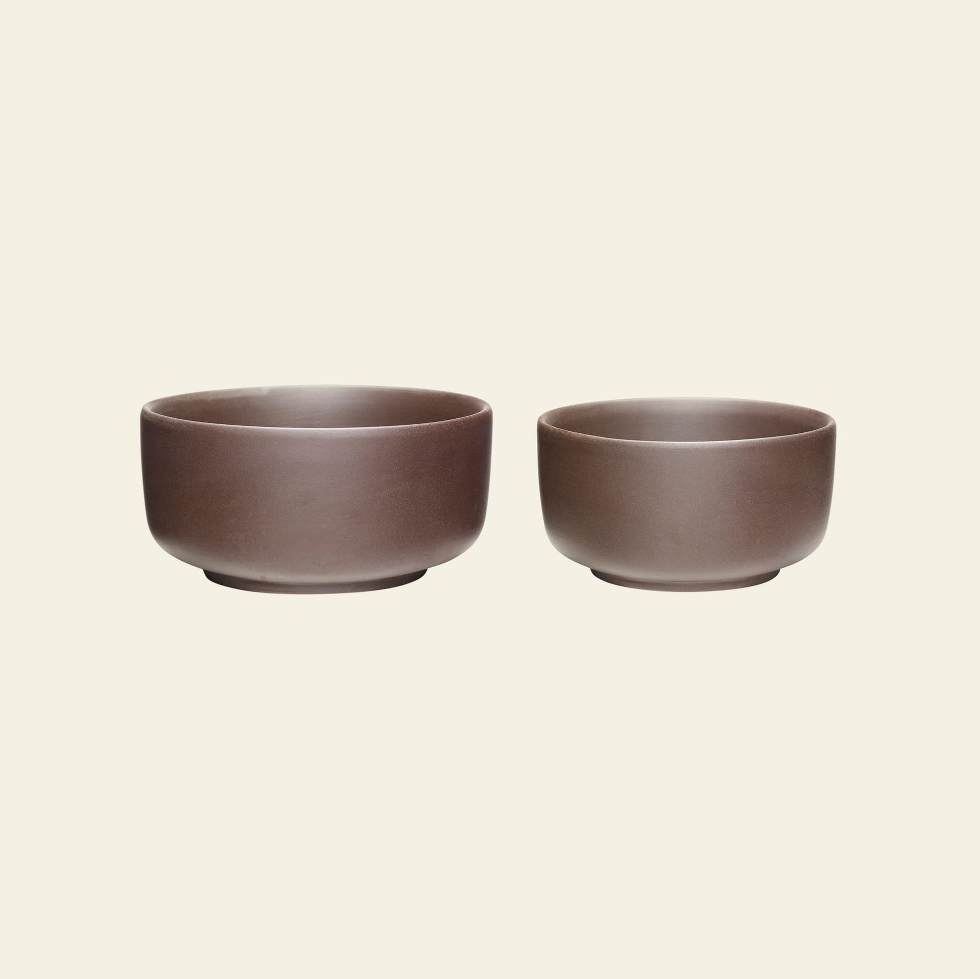 The Hübsch Clay Bowls, Set of 2 by Hübsch features elegantly designed brown ceramic bowls in different sizes, displayed side by side on a plain light beige background.