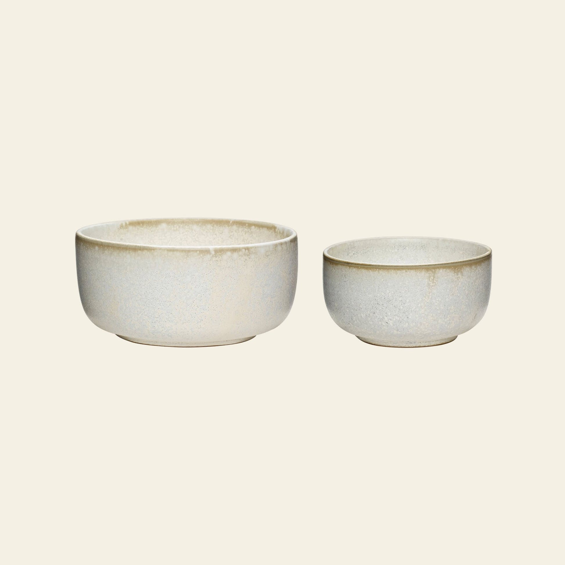Two Hübsch Clay Bowls of different sizes sit side by side on a plain background. This set of 2 from Hübsch features a simple, rounded shape and an elegant beige and gray speckled finish.
