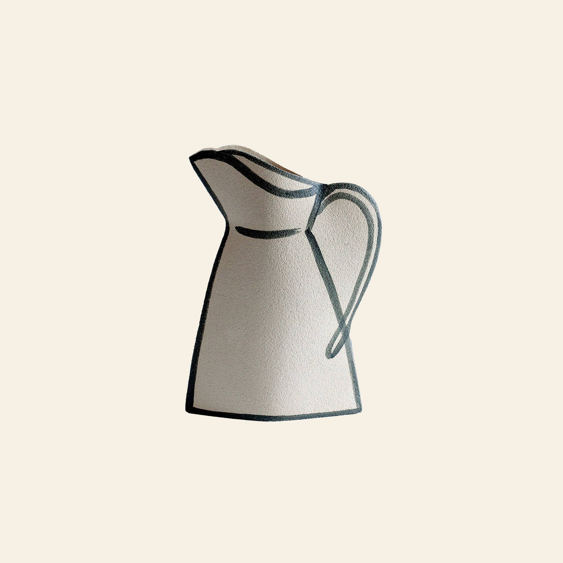 A cream-toned INI CERAMIQUE Morandi Pitcher Ceramic Vase with dark outlines, curved handle, and wide spout is set against a plain background, showcasing the artisanal craftsmanship of INI CERAMIQUE.