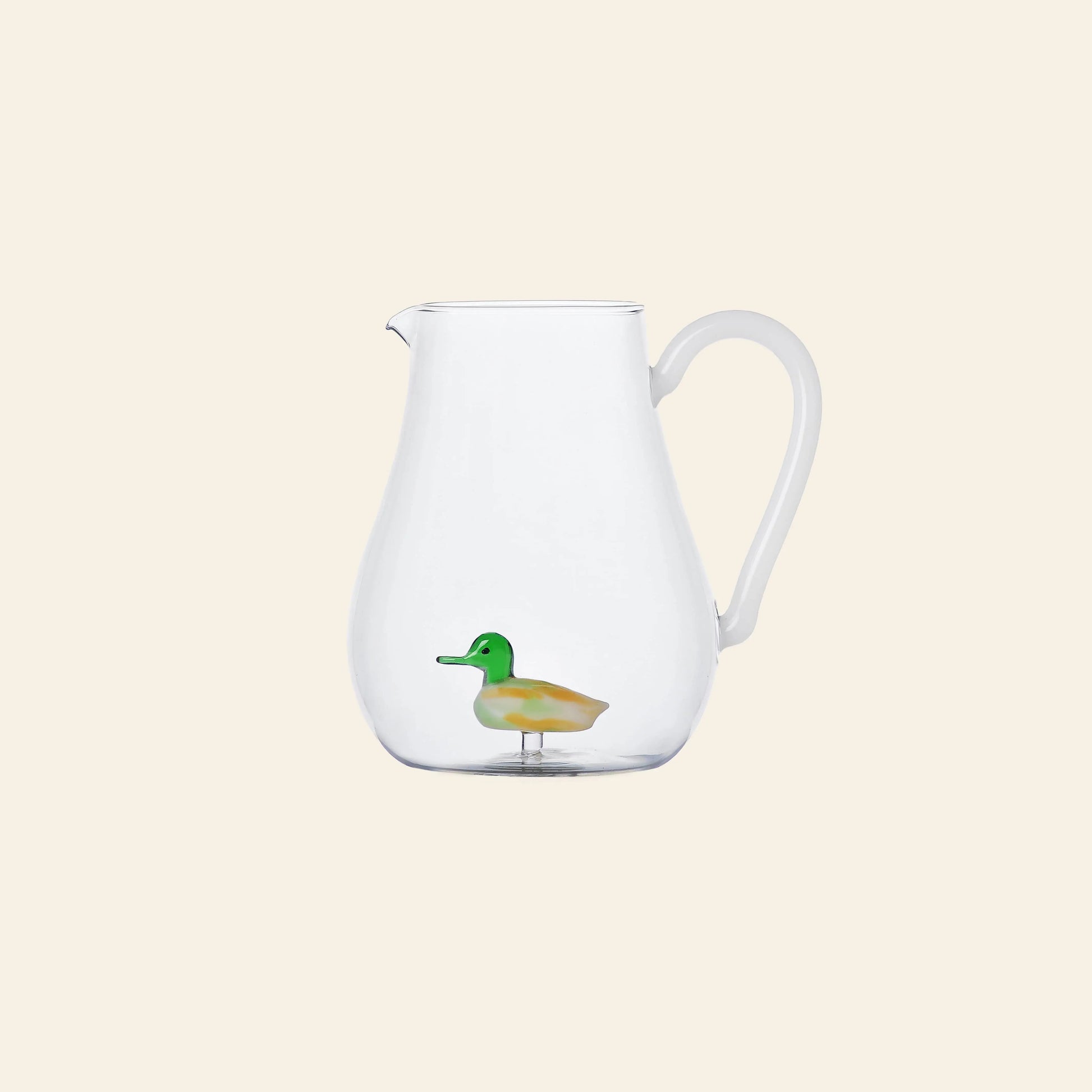 The Ichendorf Milano Animal Farm Pitcher - Duck from Stacked Store is a clear glass pitcher featuring a small, colorful duck figurine inside, displayed against a plain light beige background.