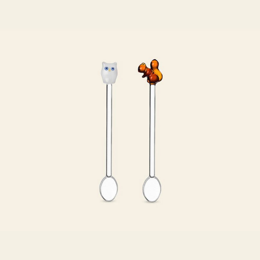 The Ichendorf Milano Animal Farm Spoons, Set of 2, feature decorative handles topped with a white owl and a brown squirrel, set against a plain light beige background.