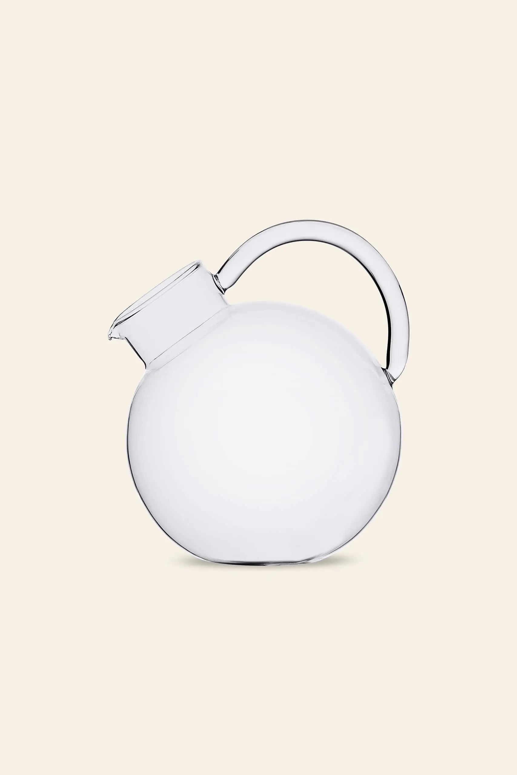 The Ichendorf Milano Bouquet Round Jug by Ichendorf Milano, featuring a clear, round glass body with a curved handle and short angled spout, is displayed against a light beige background to highlight its sleek handcrafted design.