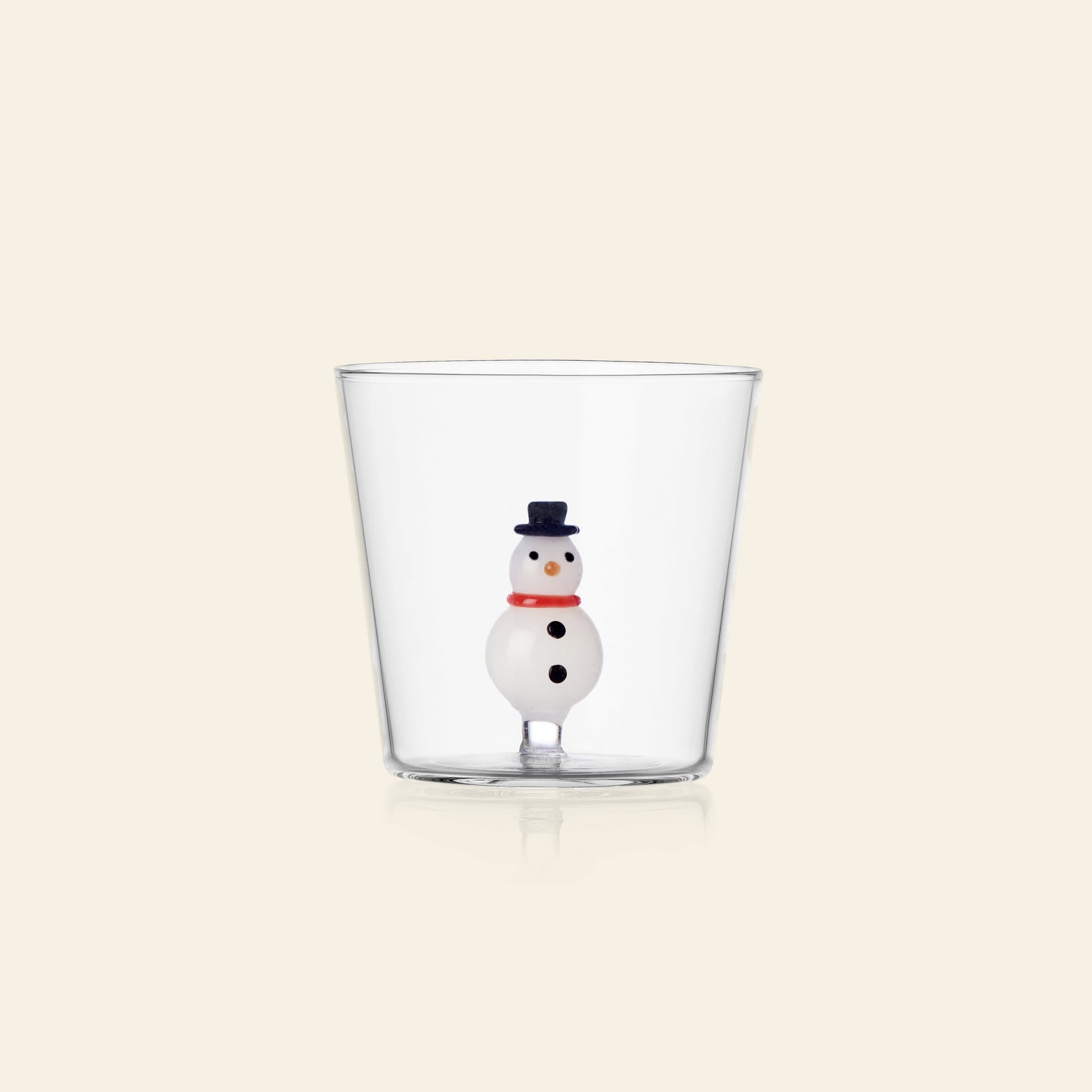 The Ichendorf Milano Christmas Tales Tumbler by Ichendorf Milano is a clear glass featuring a festive snowman with a black hat, red scarf, and black buttons at the base. A delightful choice for holiday gifting and seasonal décor.
