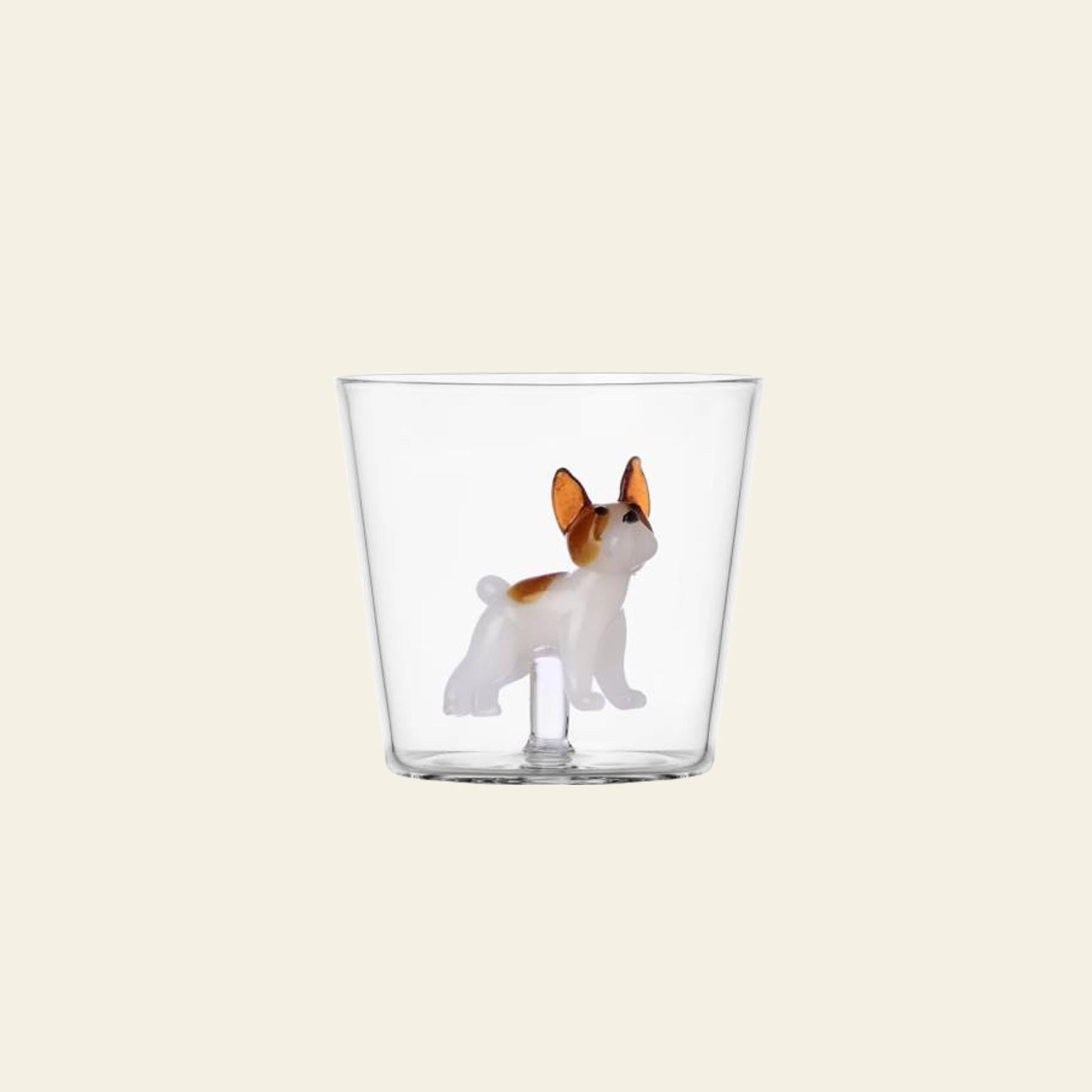The Ichendorf Milano Dogs Tumbler - French Bulldog is a clear glass tumbler by Ichendorf Milano, featuring a small brown and white French Bulldog figurine attached to the base, ideal for any dog lover’s collection.