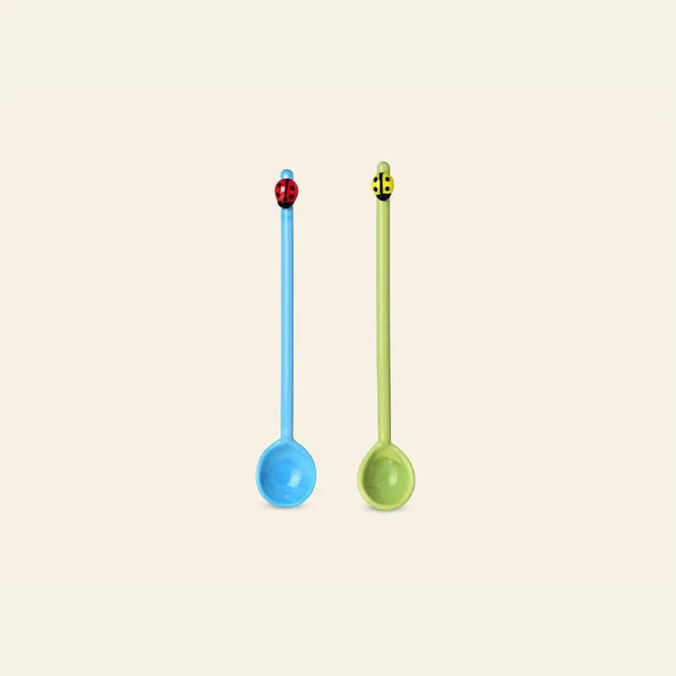 The Ichendorf Milano Fruits and Flower Teaspoons, Set of 2 by Ichendorf Milano features a blue spoon with a red ladybug and a green spoon with a yellow and black bee, both standing upright on a plain light background.
