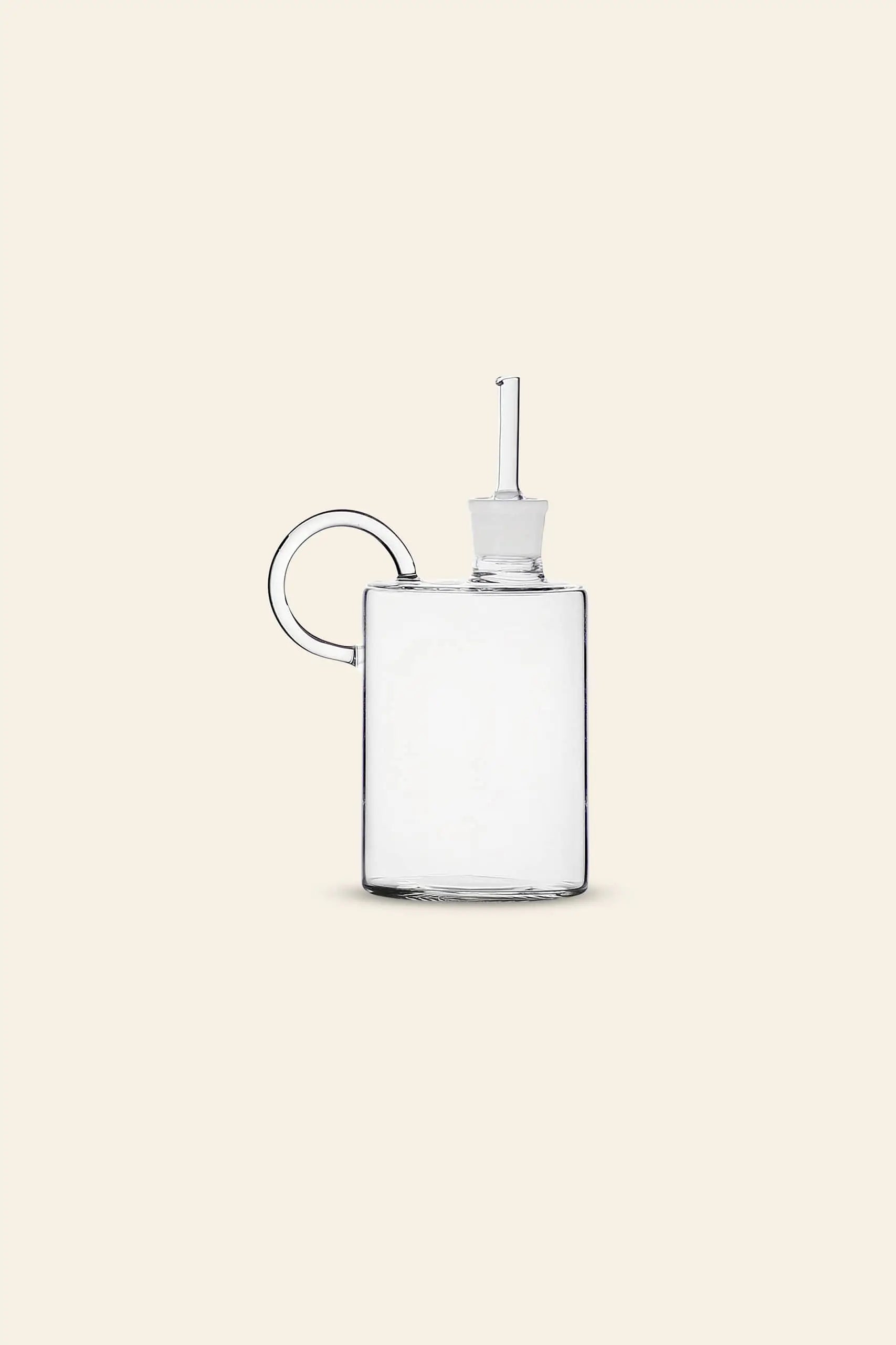 The Ichendorf Milano Tokio Balsamic Vinegar Bottle by Ichendorf Milano features a handcrafted glass design with a round handle and spout stopper, showcased elegantly against a plain beige background.