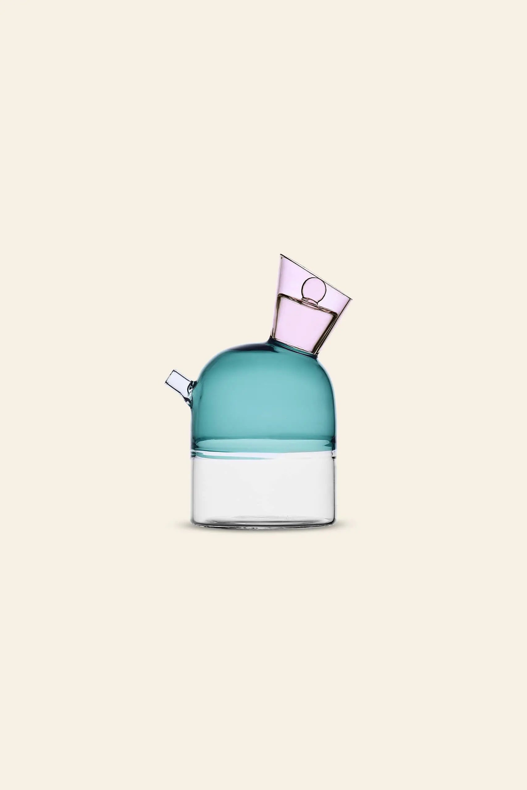 The Ichendorf Milano Travasi Oil Bottle features a transparent base, teal-blue dome, and tilted light purple spout, blending modern geometry with artistic flair—an eye-catching accent by Ichendorf Milano for contemporary table settings.
