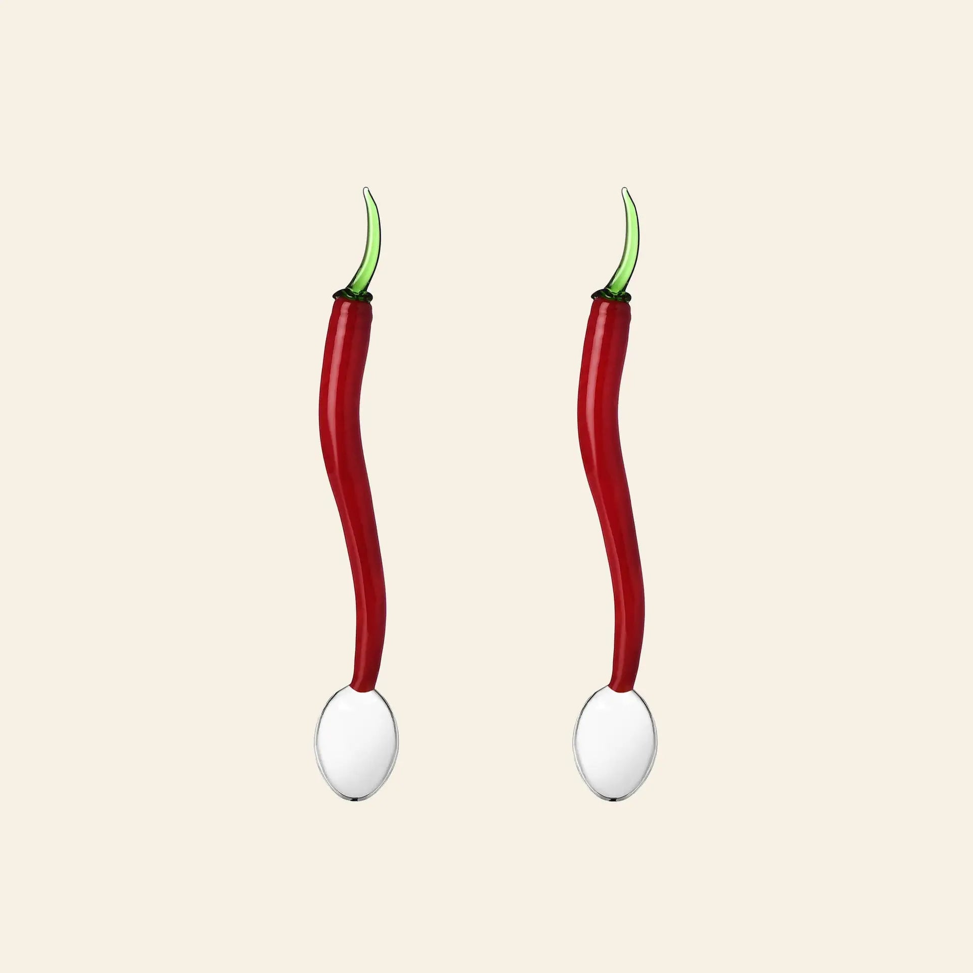 Two red chili pepper spoons with green stems from the Ichendorf Milano Vegetables Spoons, Set of 2, stand upright on white spheres against a light beige background—part of a culinary-inspired series by Ichendorf Milano.
