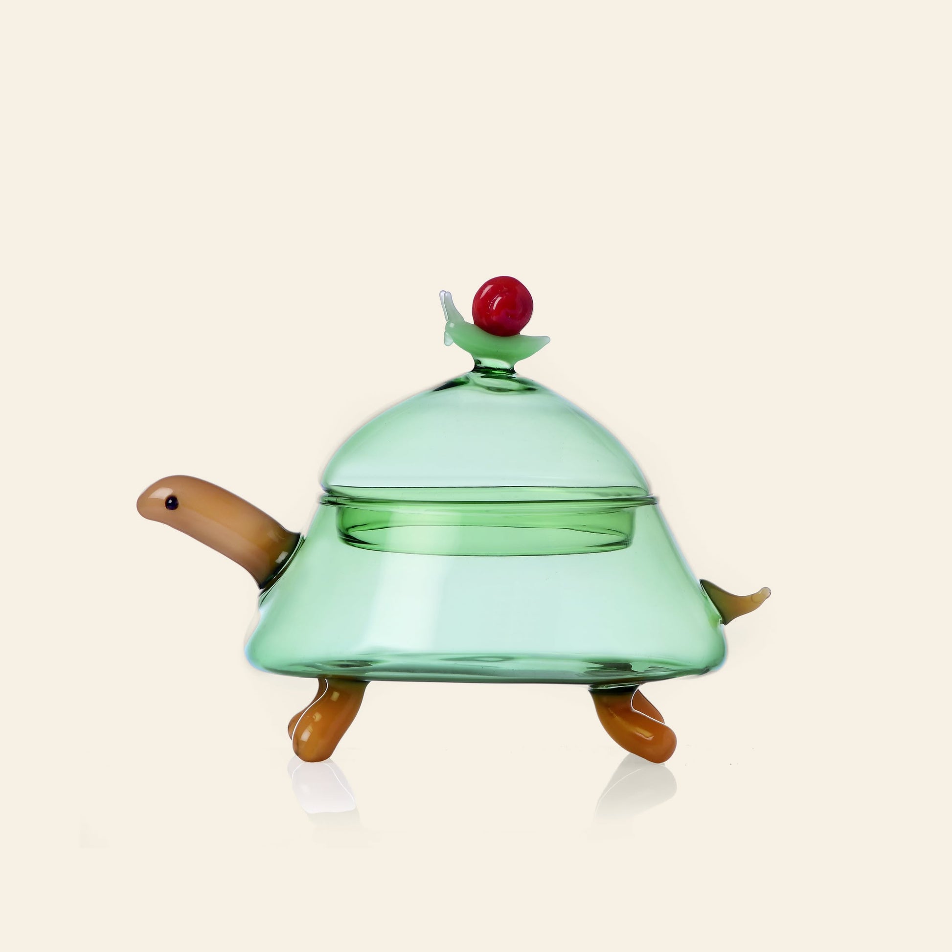 The Ichendorf Milano Woodland Tales Sugar Bowl features a turtle design with a green dome body, tan accents, and a red cherry top—adding whimsical charm from nature to any space. Crafted by Ichendorf Milano. Plain light background.