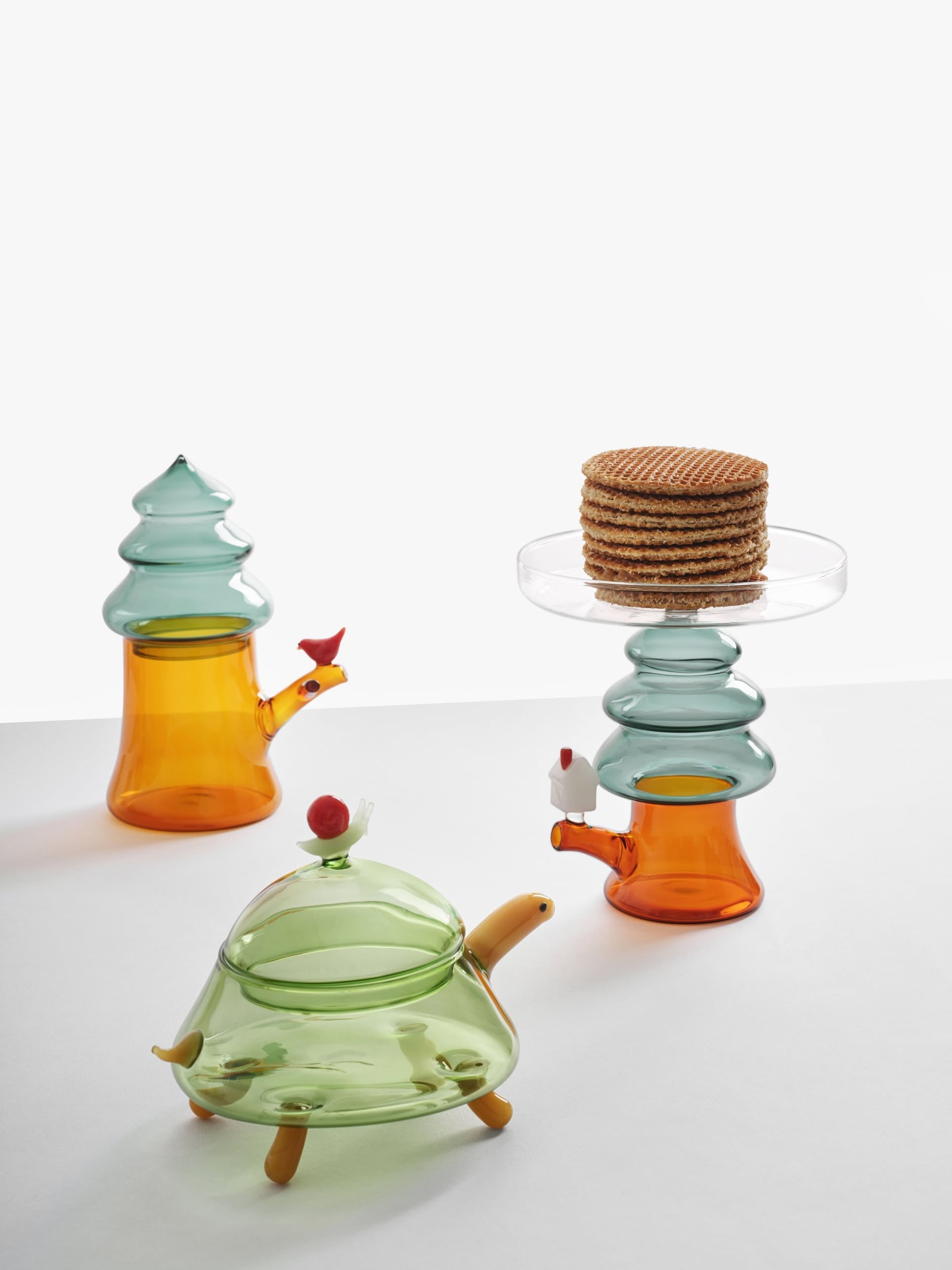 The Ichendorf Milano Woodland Tales Sugar Bowl, shaped like a turtle with a bird figurine, brings whimsical, nature-inspired charm to any setting, displayed here on a white surface next to cookies.