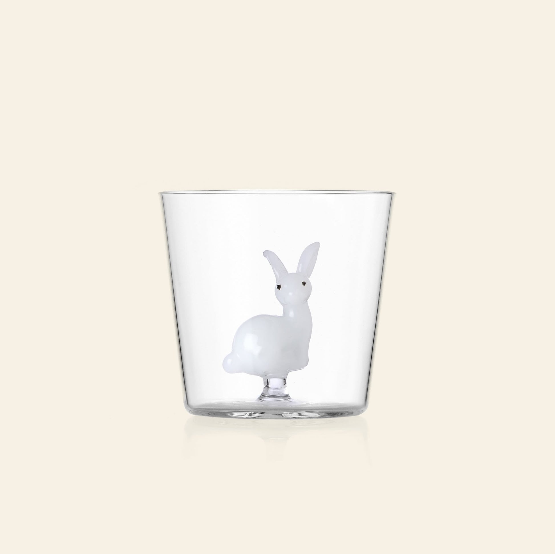 The Ichendorf Milano Woodland Tales Tumbler is a clear glass cup featuring a small white rabbit figurine at its base, handcrafted by Ichendorf Milano and inspired by woodland creatures—a charming decor piece.