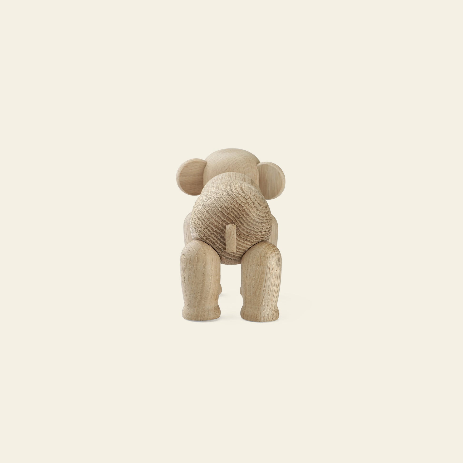 A wooden elephant figurine viewed from behind, displaying its rounded head, back, and tail with legs slightly apart—an iconic example of Danish design from Kay Bojesen—set against a plain, light background. Product: Kay Bojesen Elephant Mini.