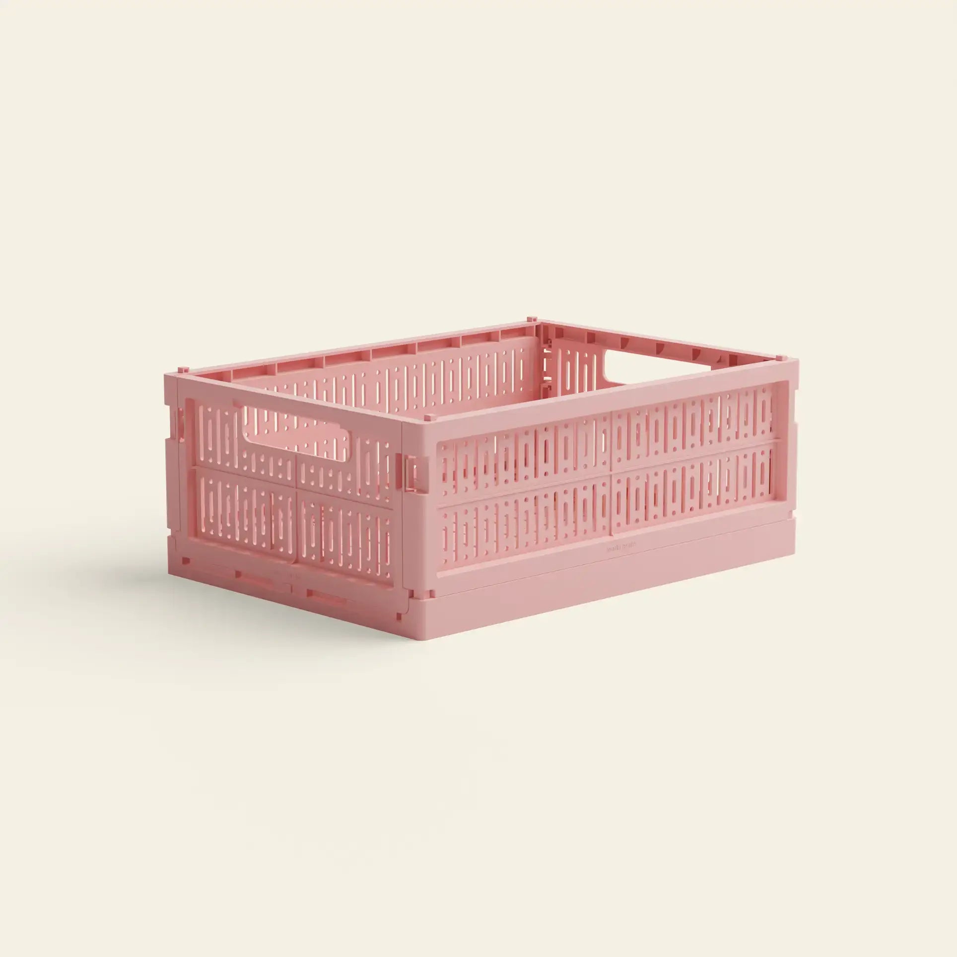 The Made Crate Midi by Made Crate is a pink, rectangular storage crate with ventilated sides and handles, made from recycled plastic for easy stacking, shown on a plain light-colored background.