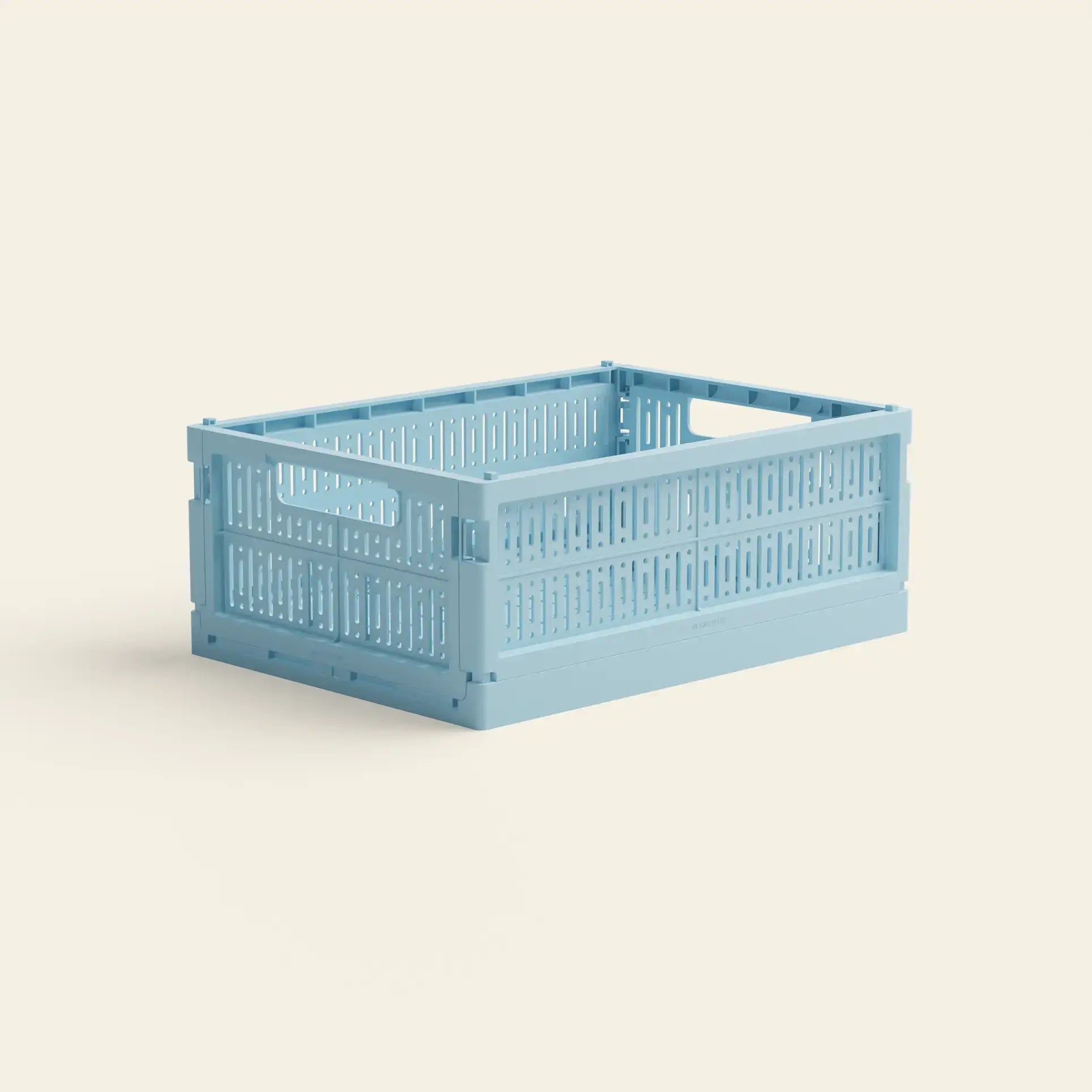 The Made Crate Midi by Made Crate is a light blue, rectangular storage crate with slotted sides and handles, made from recycled plastic for easy stacking and organization, shown on a plain off-white background.