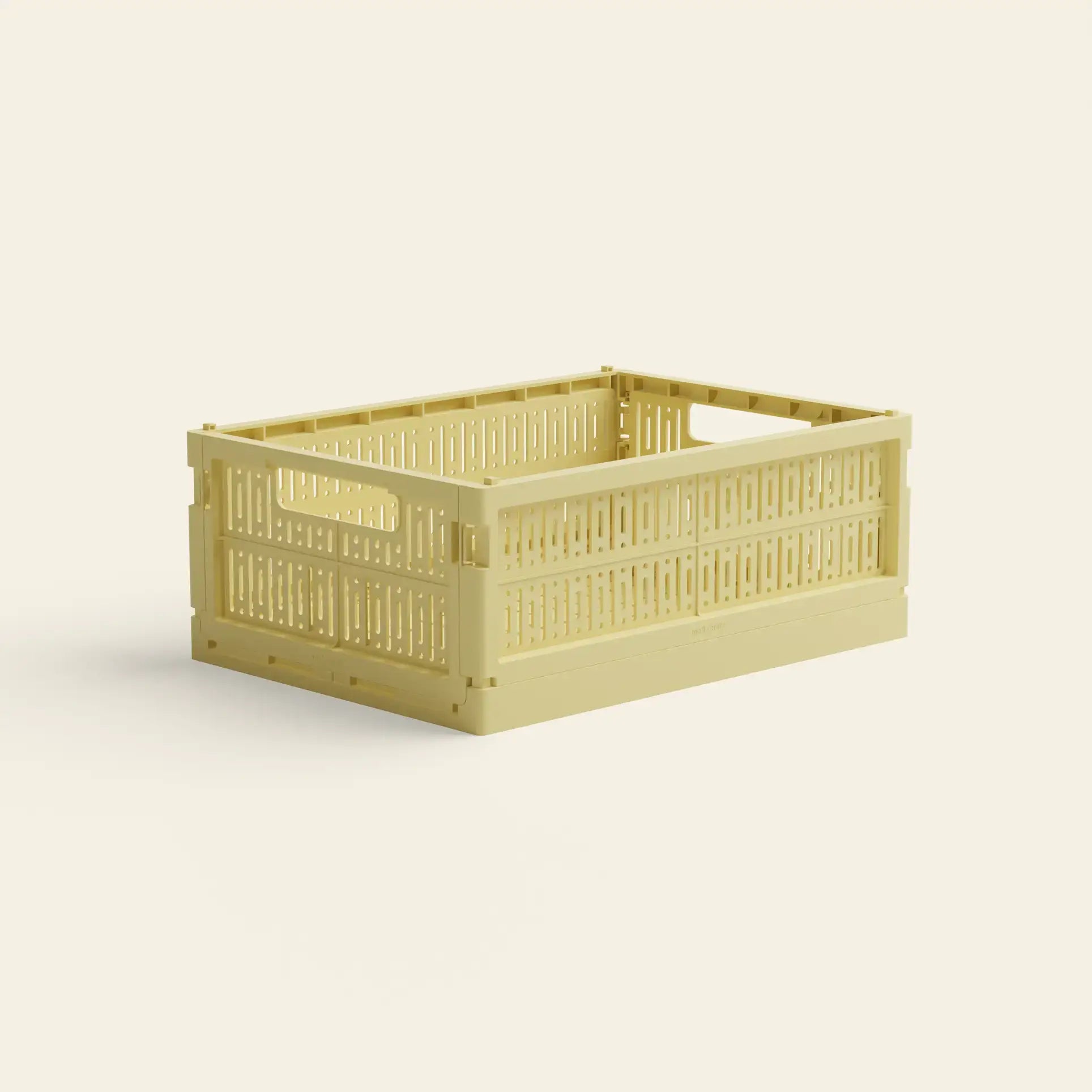 The Made Crate Midi by Made Crate is a light yellow, rectangular storage crate made from recycled plastic with open handles and slotted sides for easy stacking, shown against a plain off-white background.
