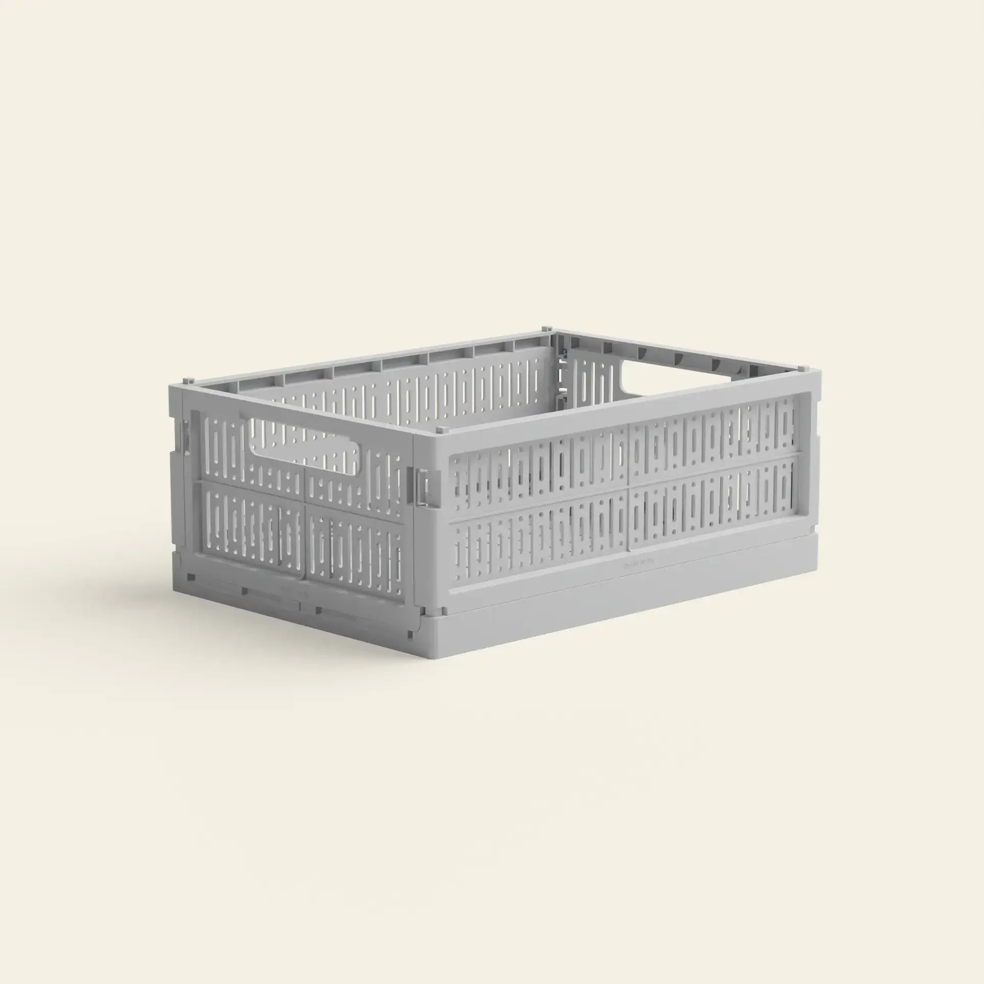 The Made Crate Midi by Made Crate is a light gray, rectangular storage crate crafted from recycled plastic with ventilated sides, handles for easy carrying, and stackable design, shown on a plain off-white background.